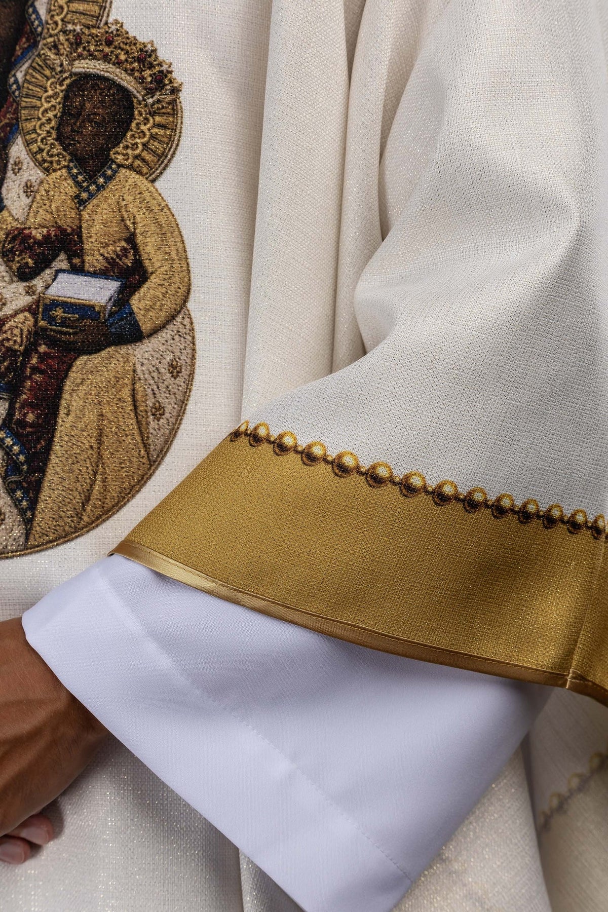 Printed chasuble detail showing Our Lady and Child image beside gold sleeve trim