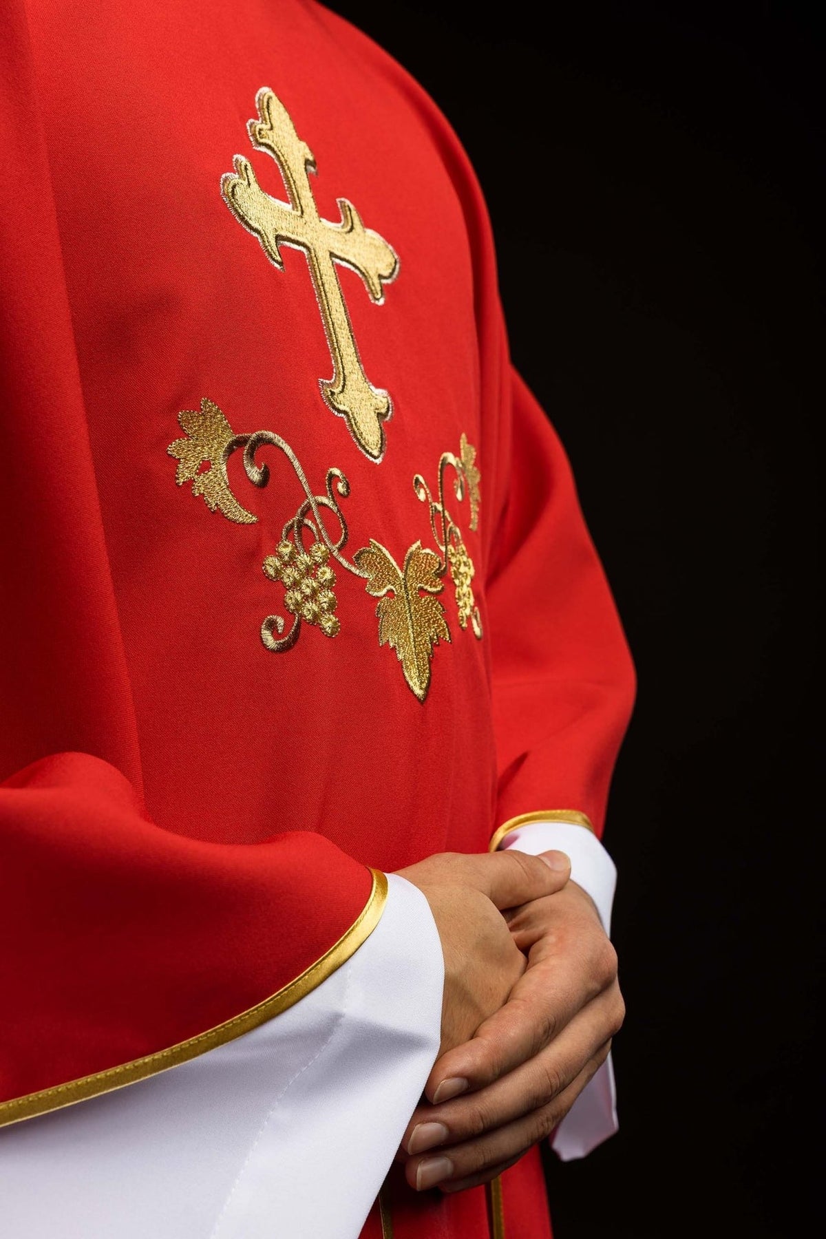Red chasuble side view showing gold cross, grape embroidery and trim