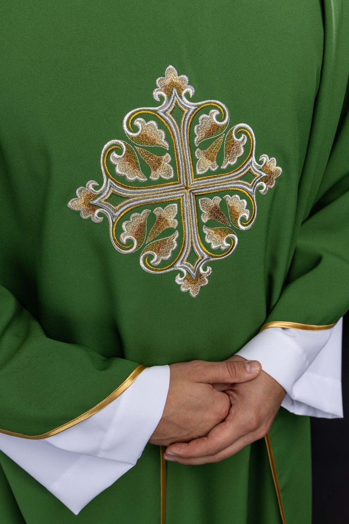 Green chasuble close-up showing embroidered cross in white and gold