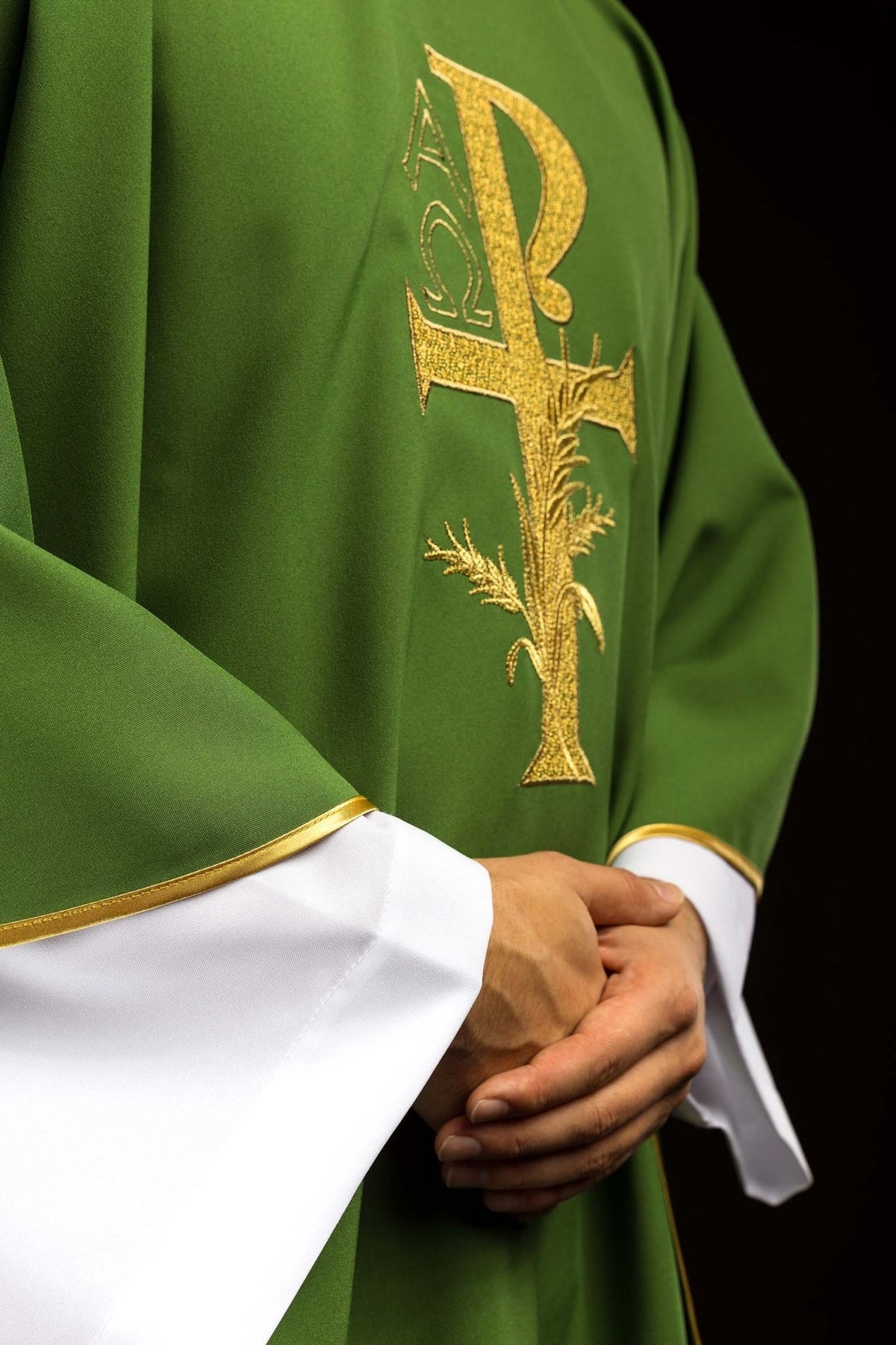 Green chasuble side close-up with gold cross embroidery and trim