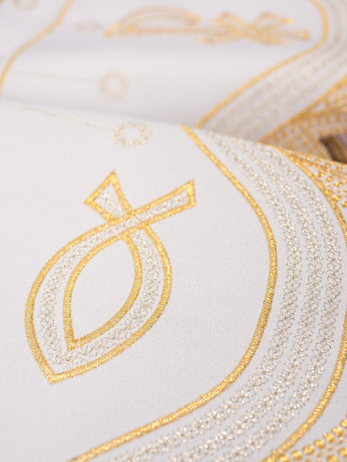 PAX altar lace close-up showing white and gold embroidery with fish and cross motifs