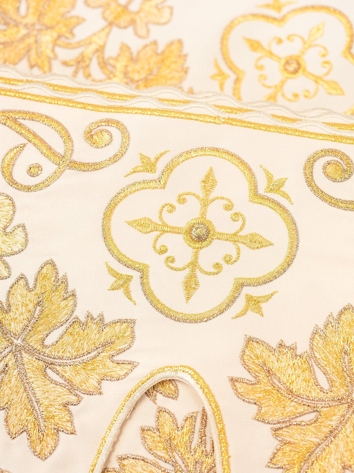 Altar lace close-up showing gold cross motif, floral embroidery and decorative border