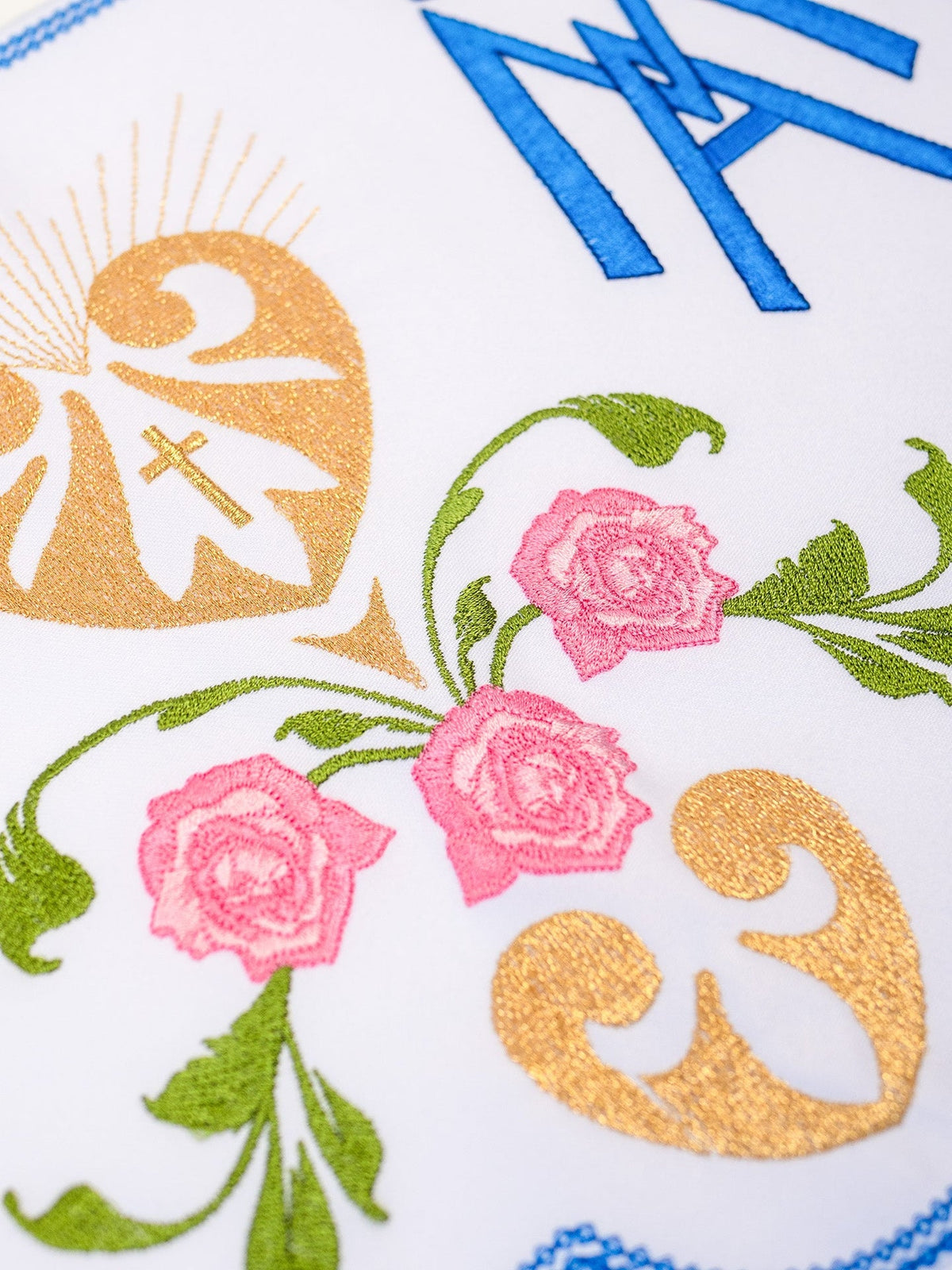 Altar lace close-up showing Marian motif, gold embroidery and pink roses