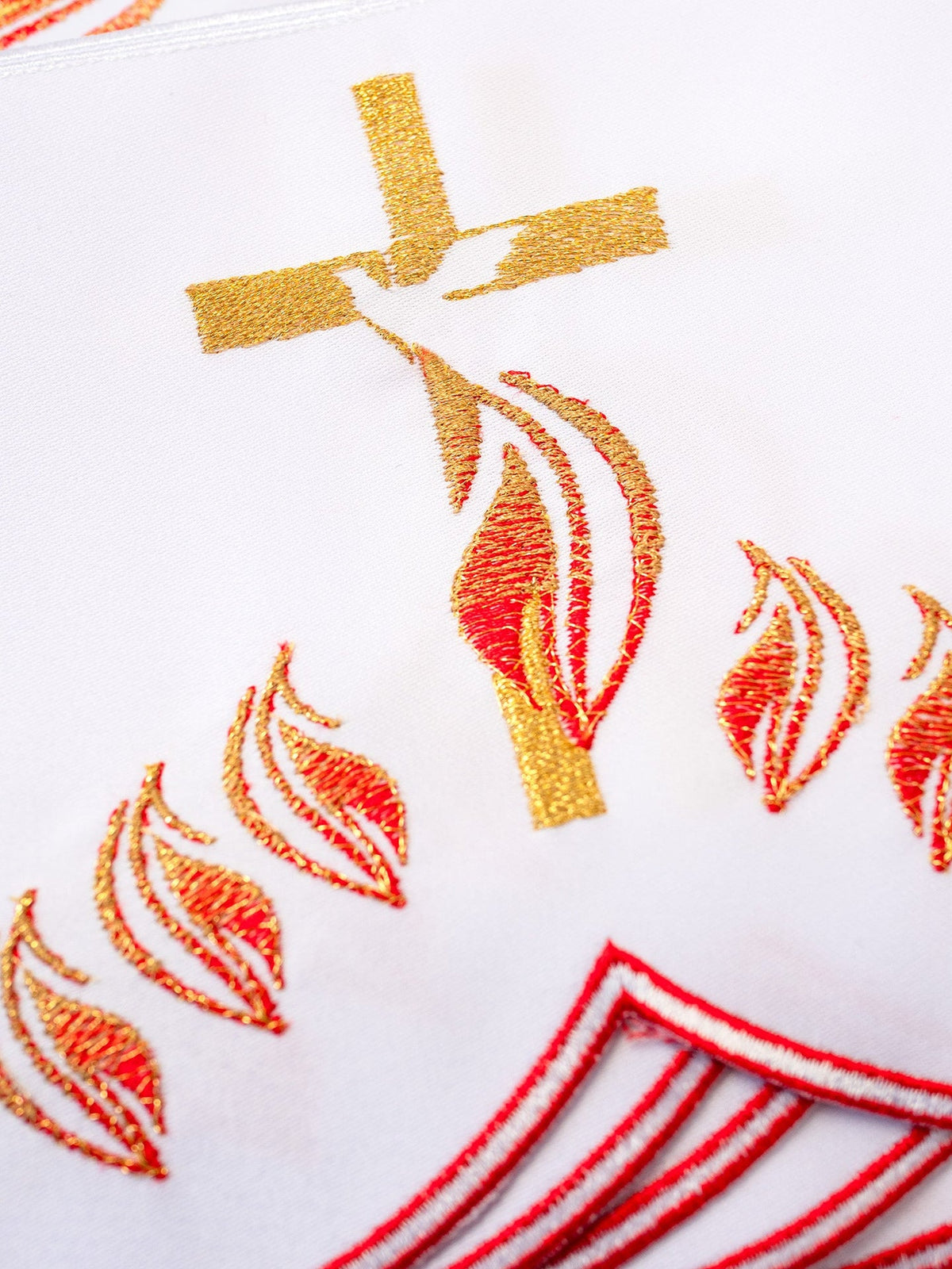 Altar lace close-up showing gold cross, red flames, and scalloped red edging