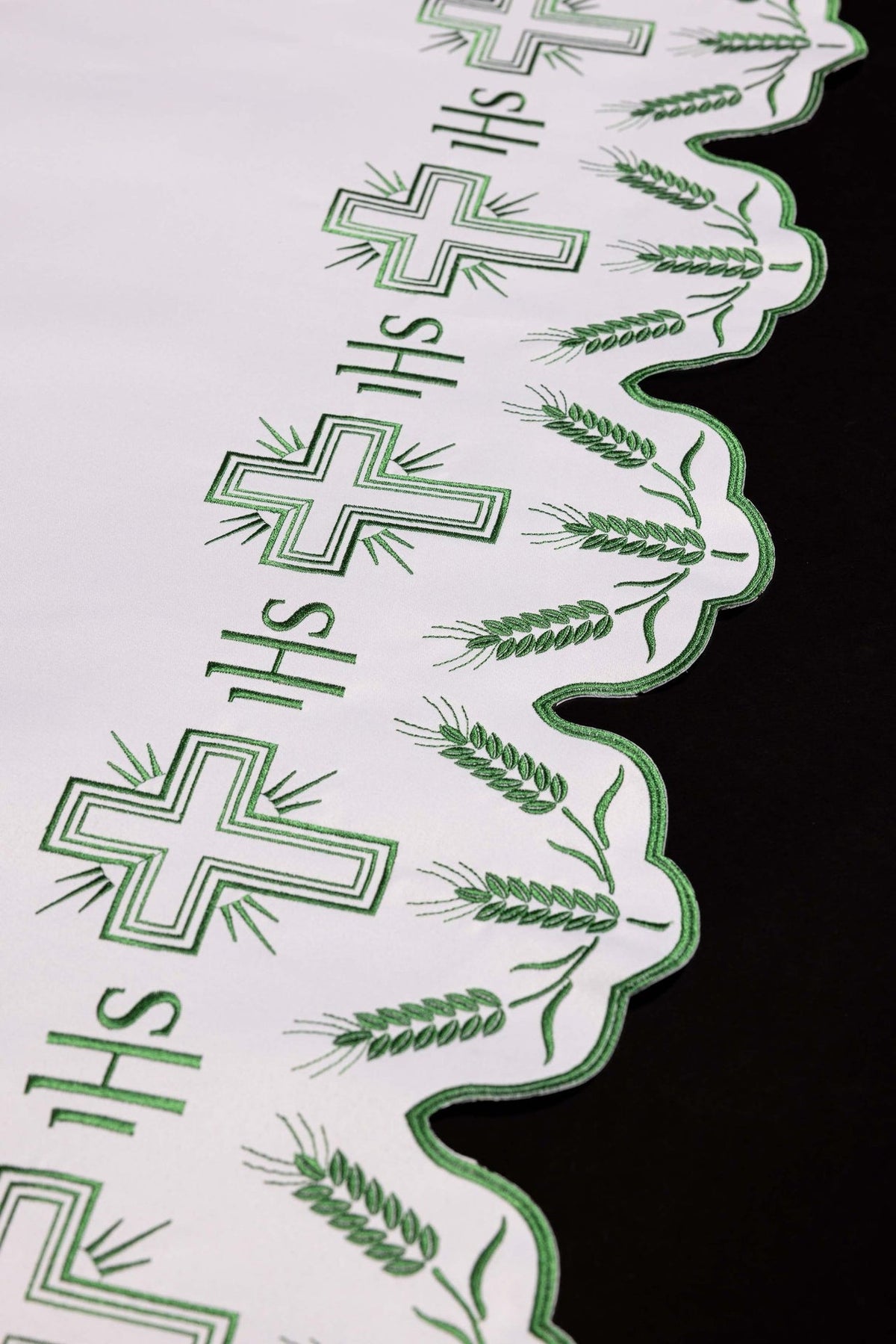 Altar cloth close-up showing scalloped trim with green cross and wheat embroidery