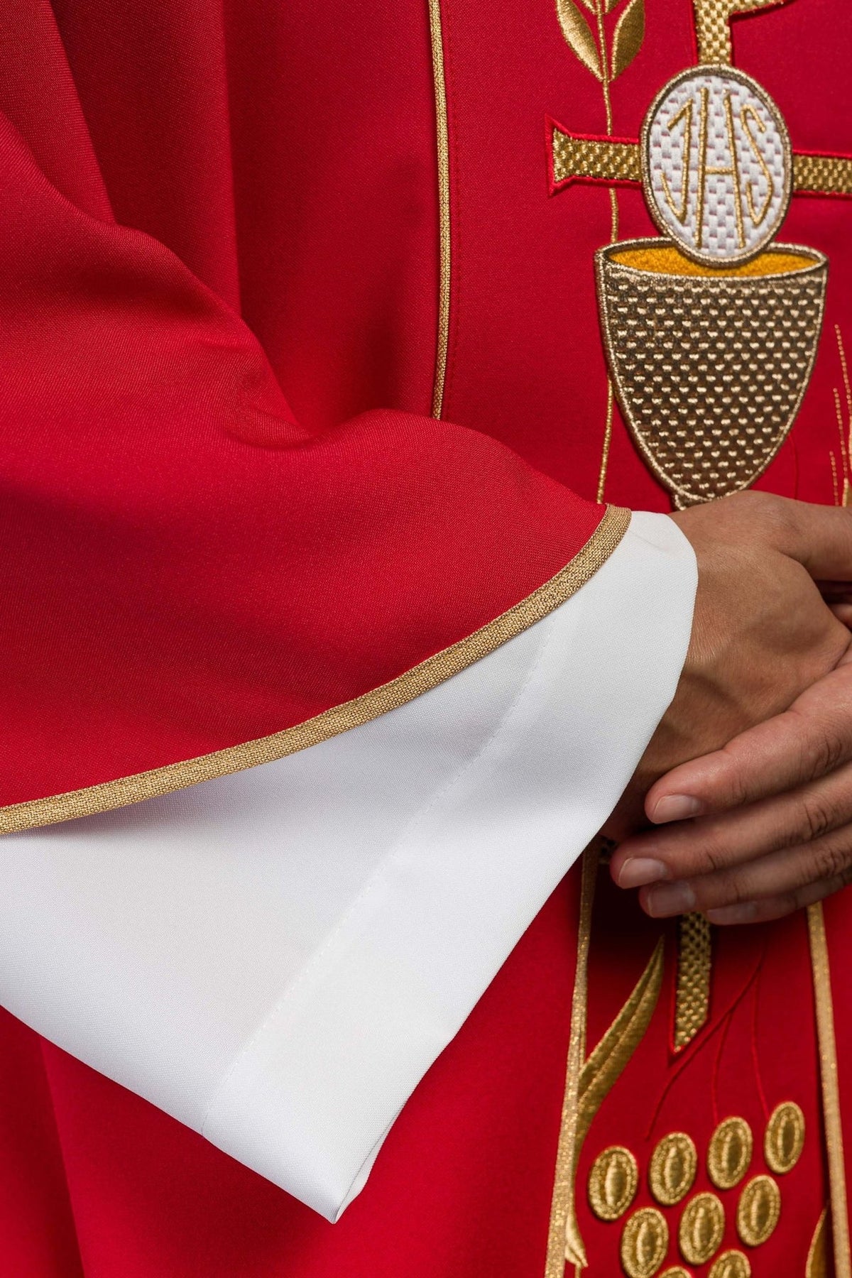 Red chasuble detail showing gold chalice embroidery and red satin fabric