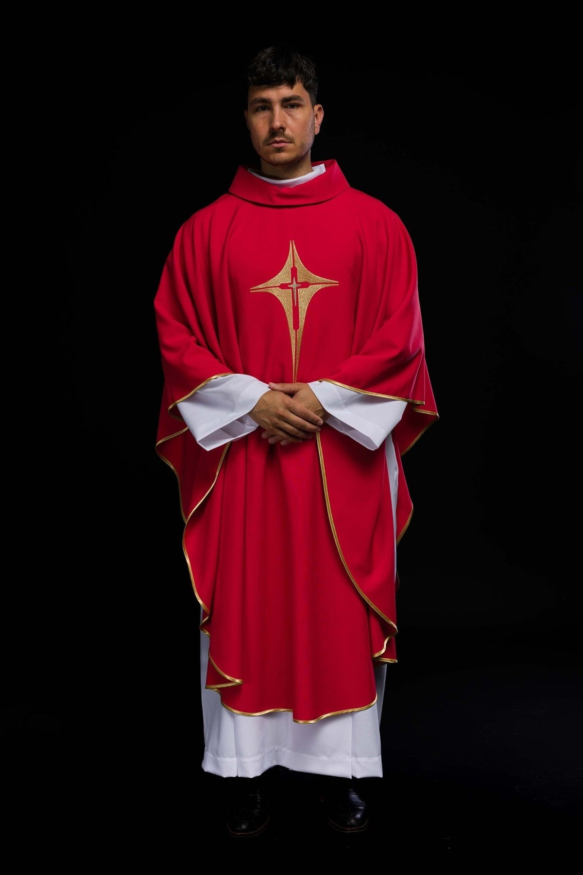 Red chasuble worn full-length from the front, showing gold cross embroidery and trim