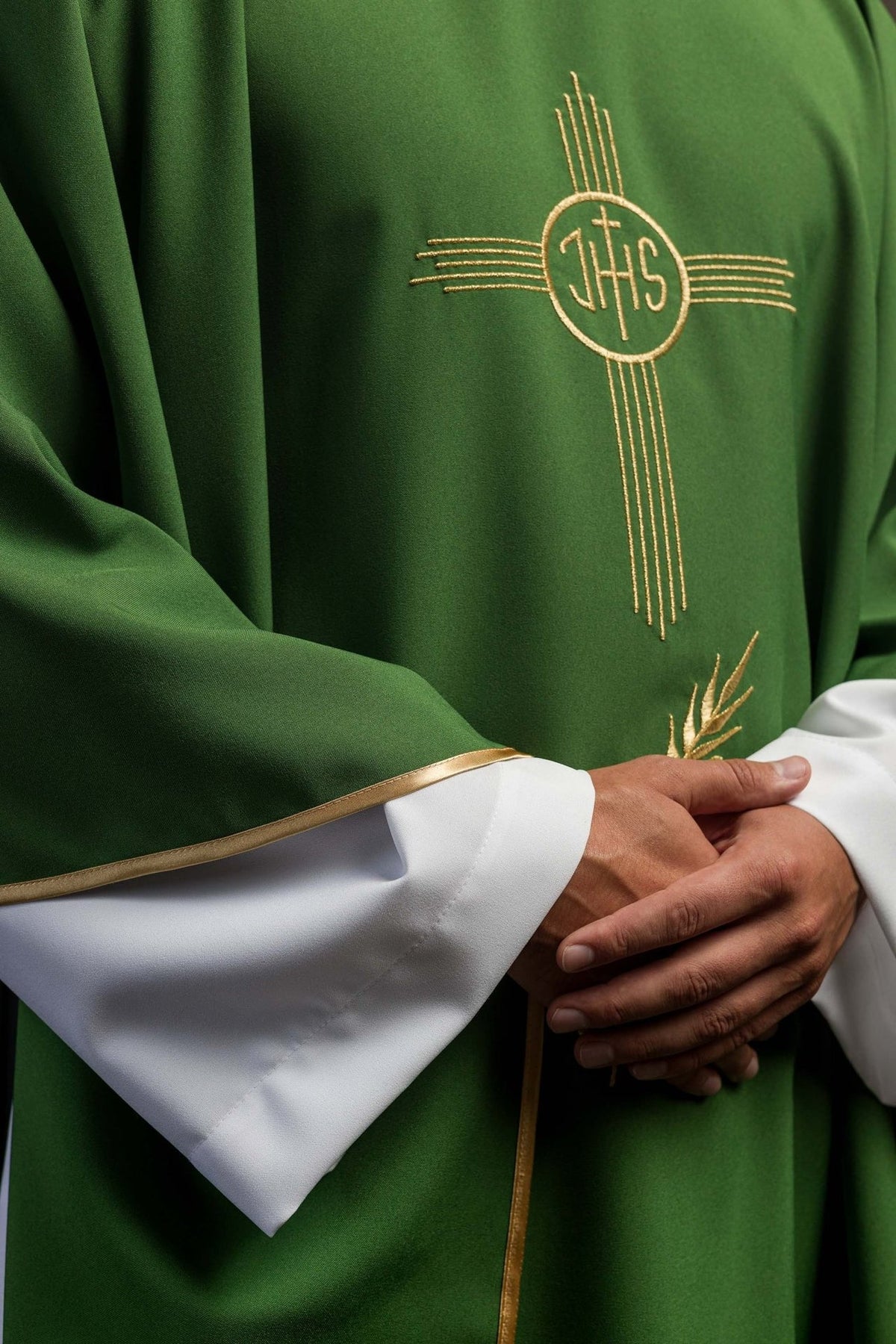 Green chasuble detail showing gold IHS embroidery and floral motif