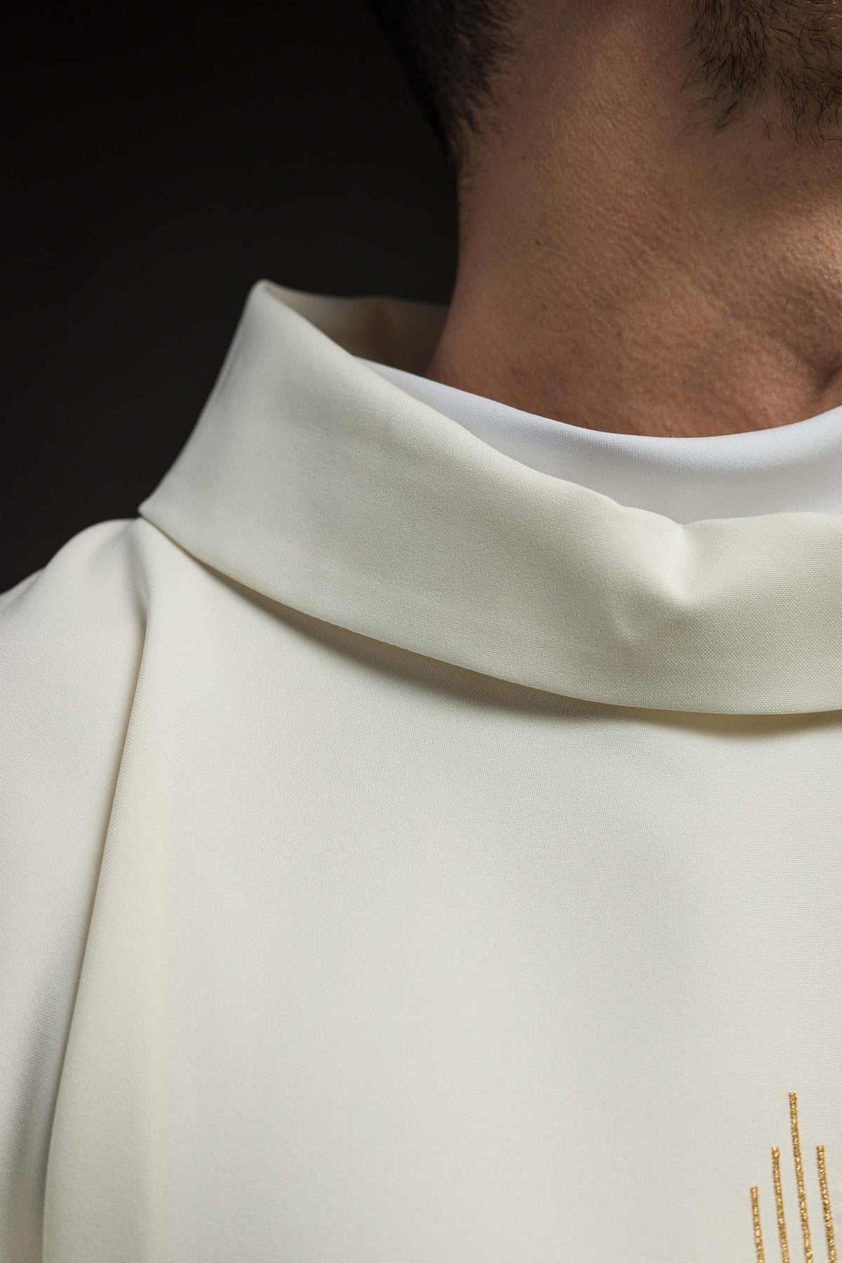 Ecru chasuble detail showing gold trim at the sleeve edge