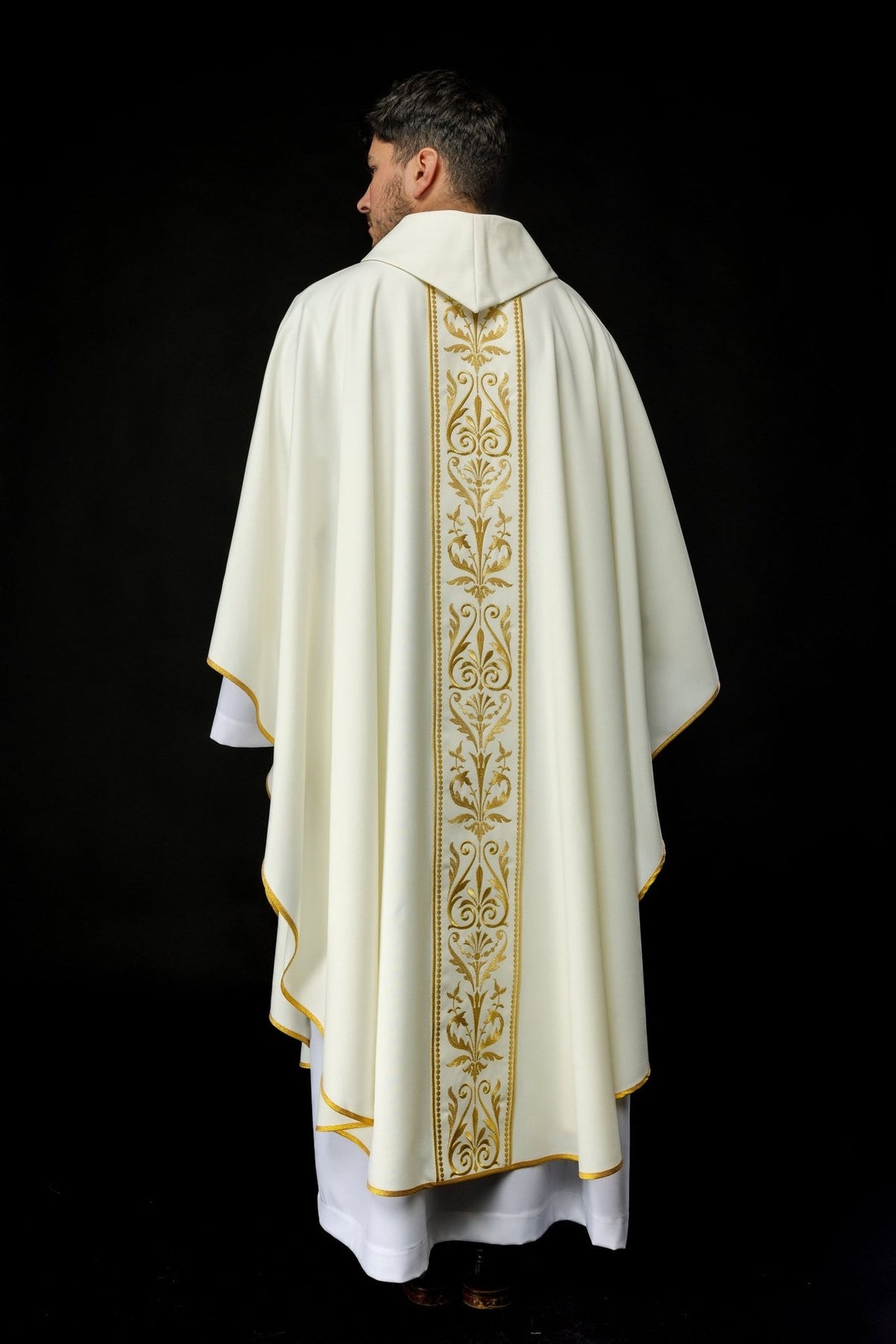 Ecru chasuble worn front view showing flowing sleeves, gold trim and embroidered orphrey
