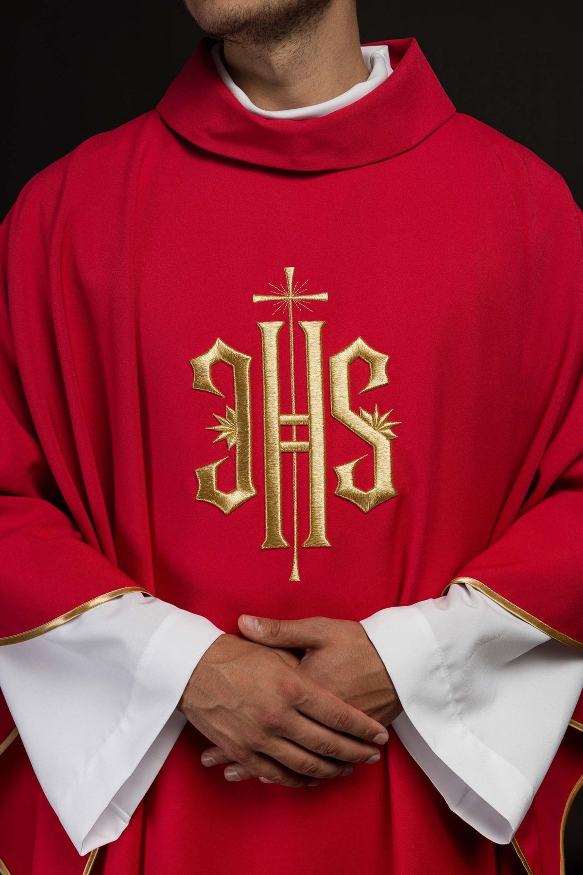 Red chasuble front close-up showing gold IHS embroidery and stand-up collar