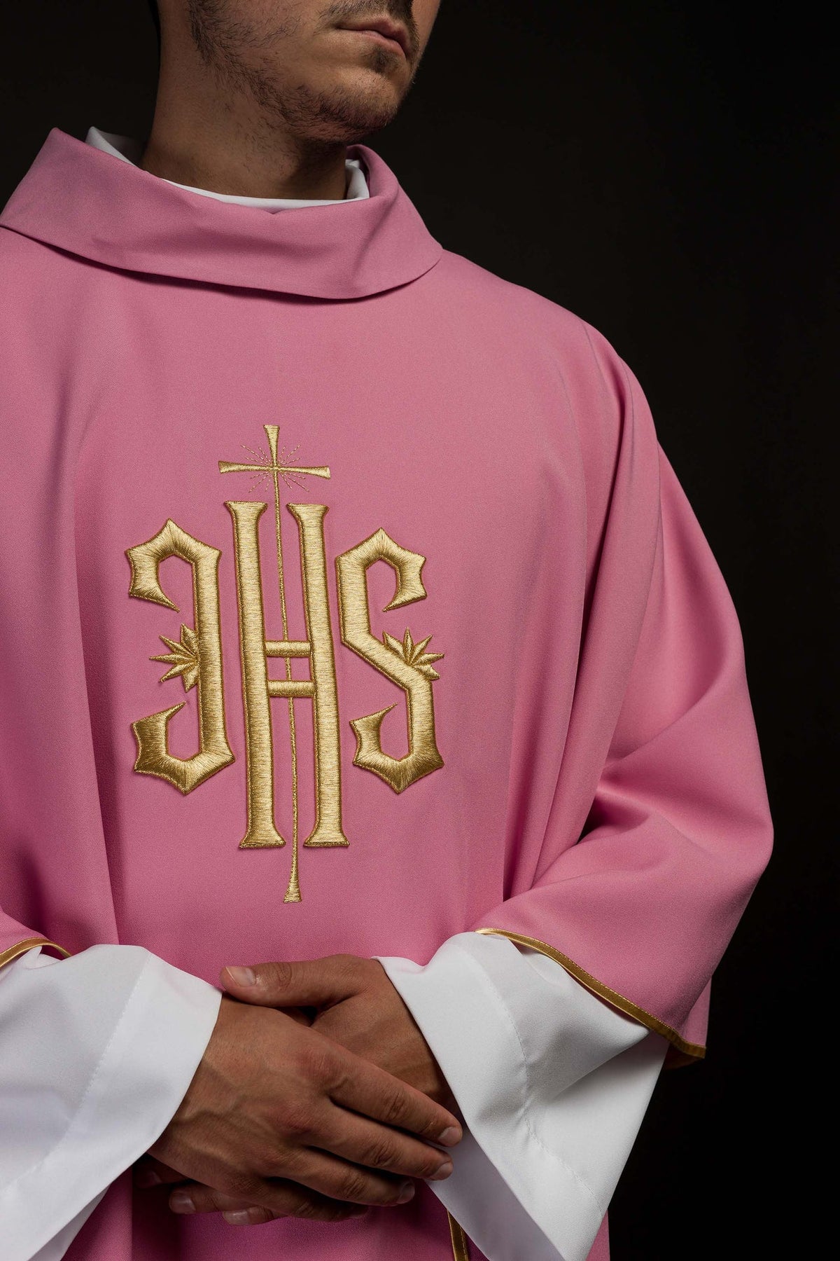 Rose chasuble close-up showing gold IHS embroidery and stand-up collar