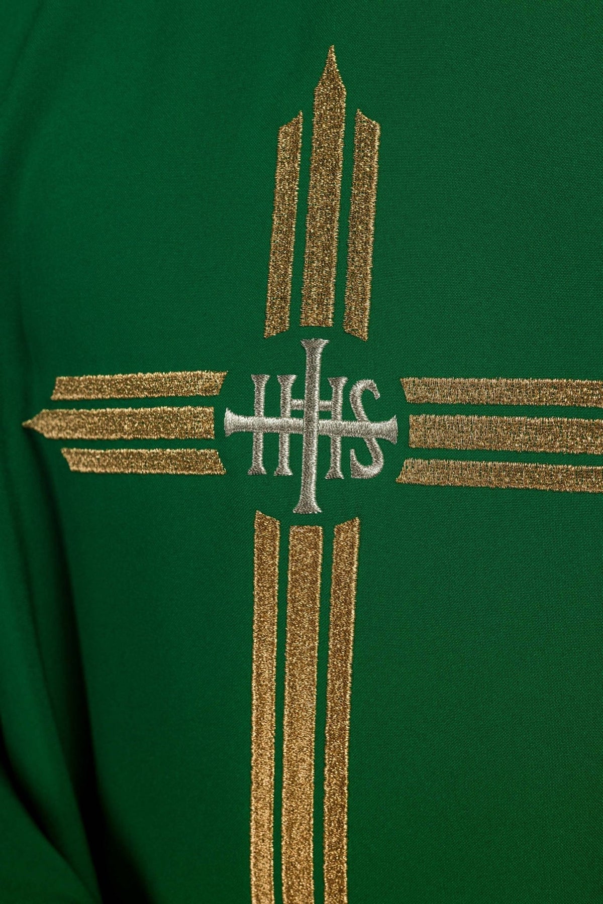 Green chasuble close-up showing gold IHS cross embroidery and sleeve trim