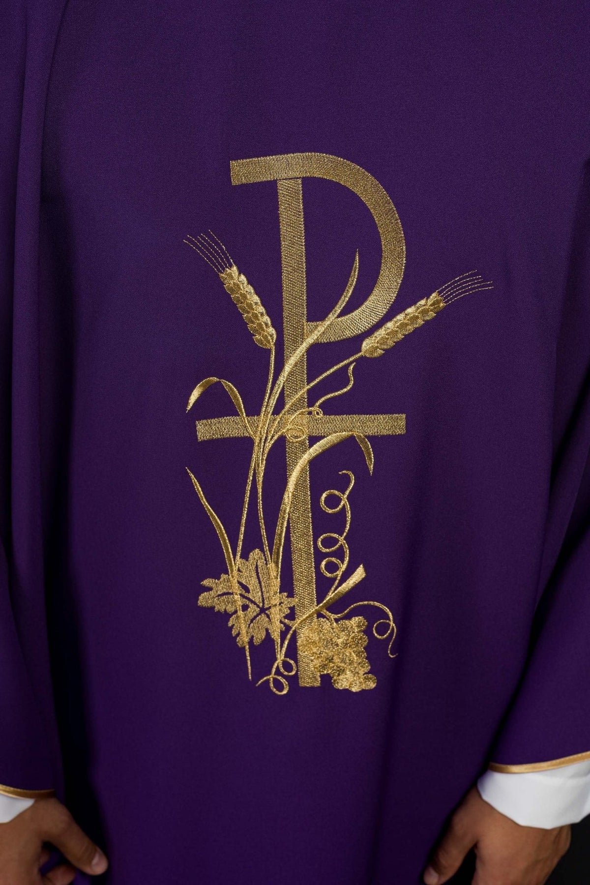 Purple chasuble close-up showing gold PAX cross and wheat embroidery