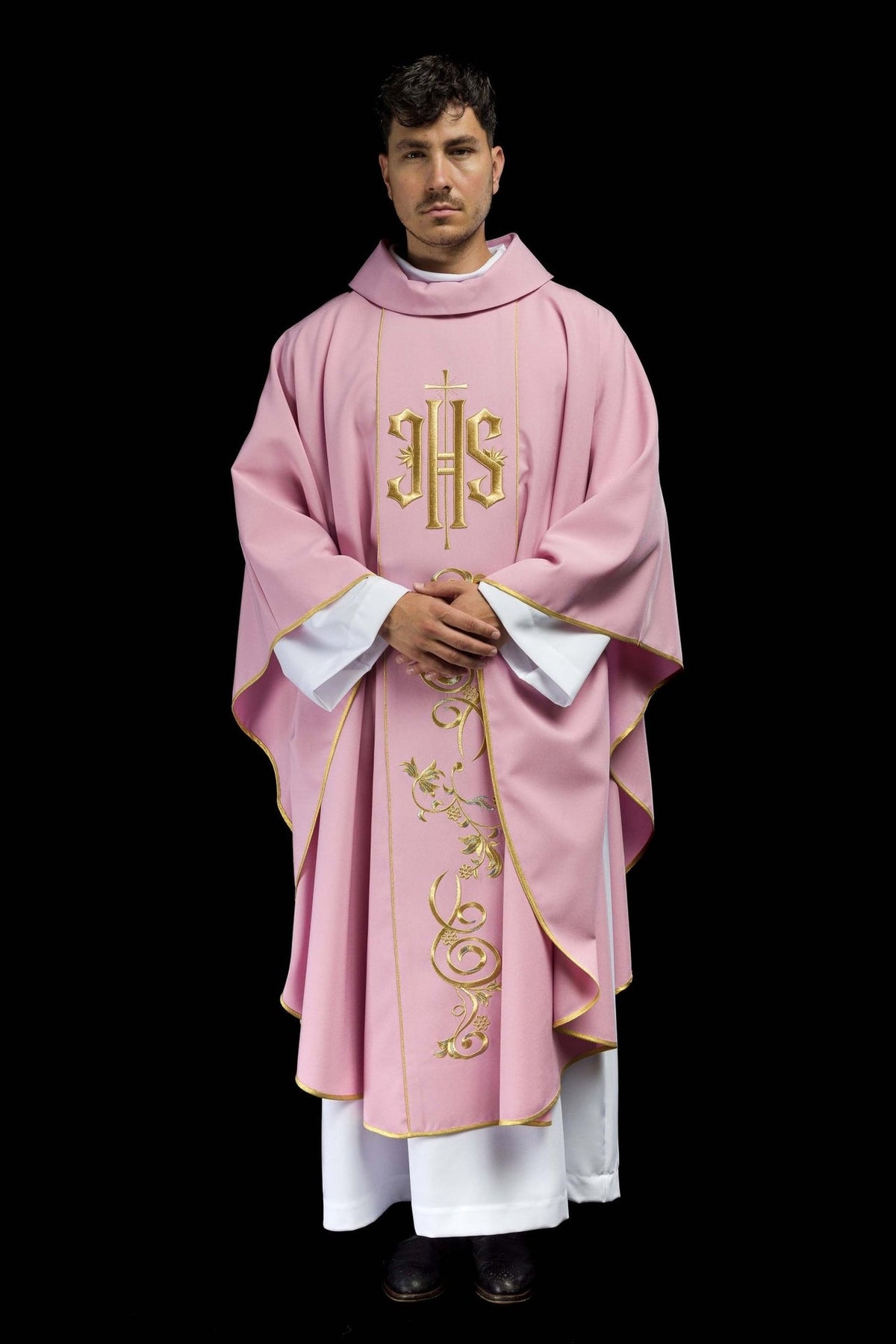 Rose chasuble worn front view with gold IHS, floral embroidery and trim