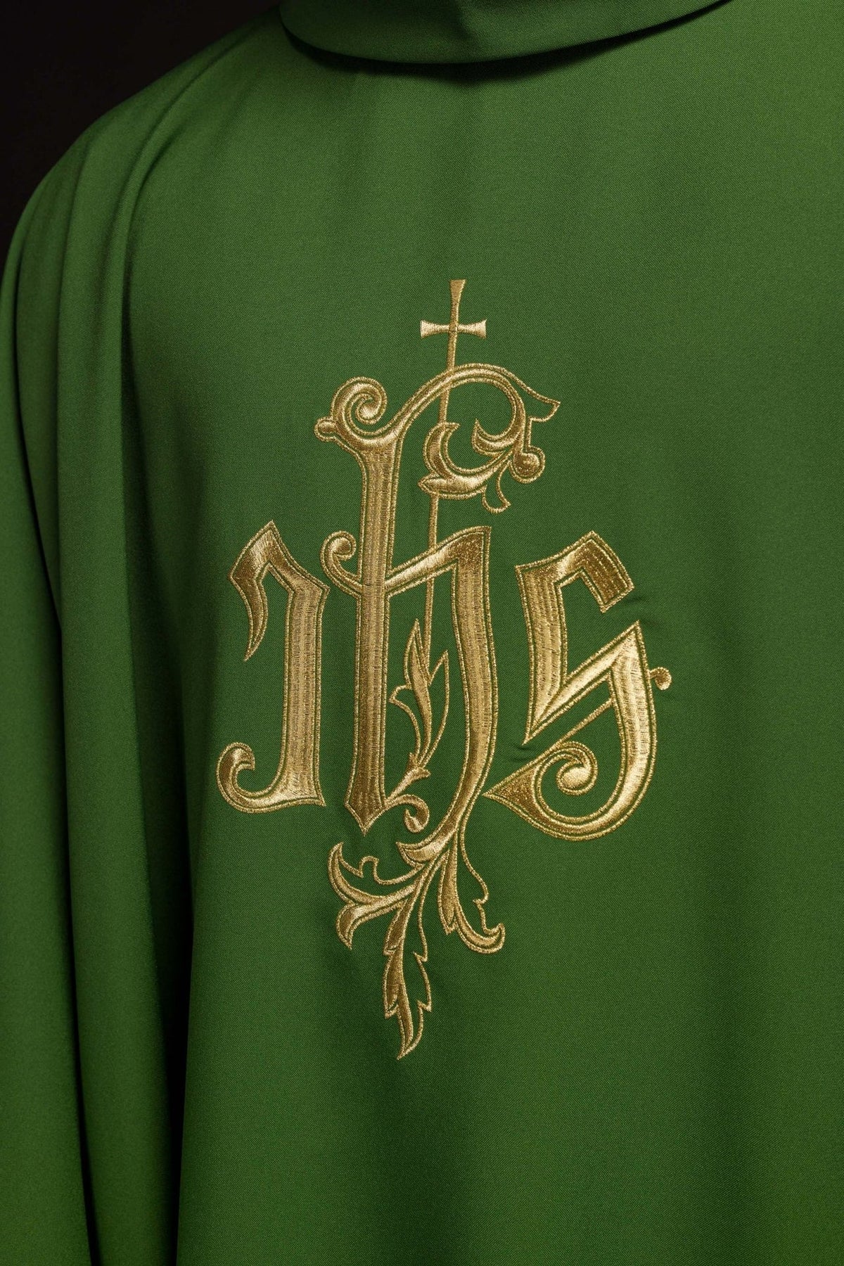 Green chasuble close-up showing gold IHS embroidery