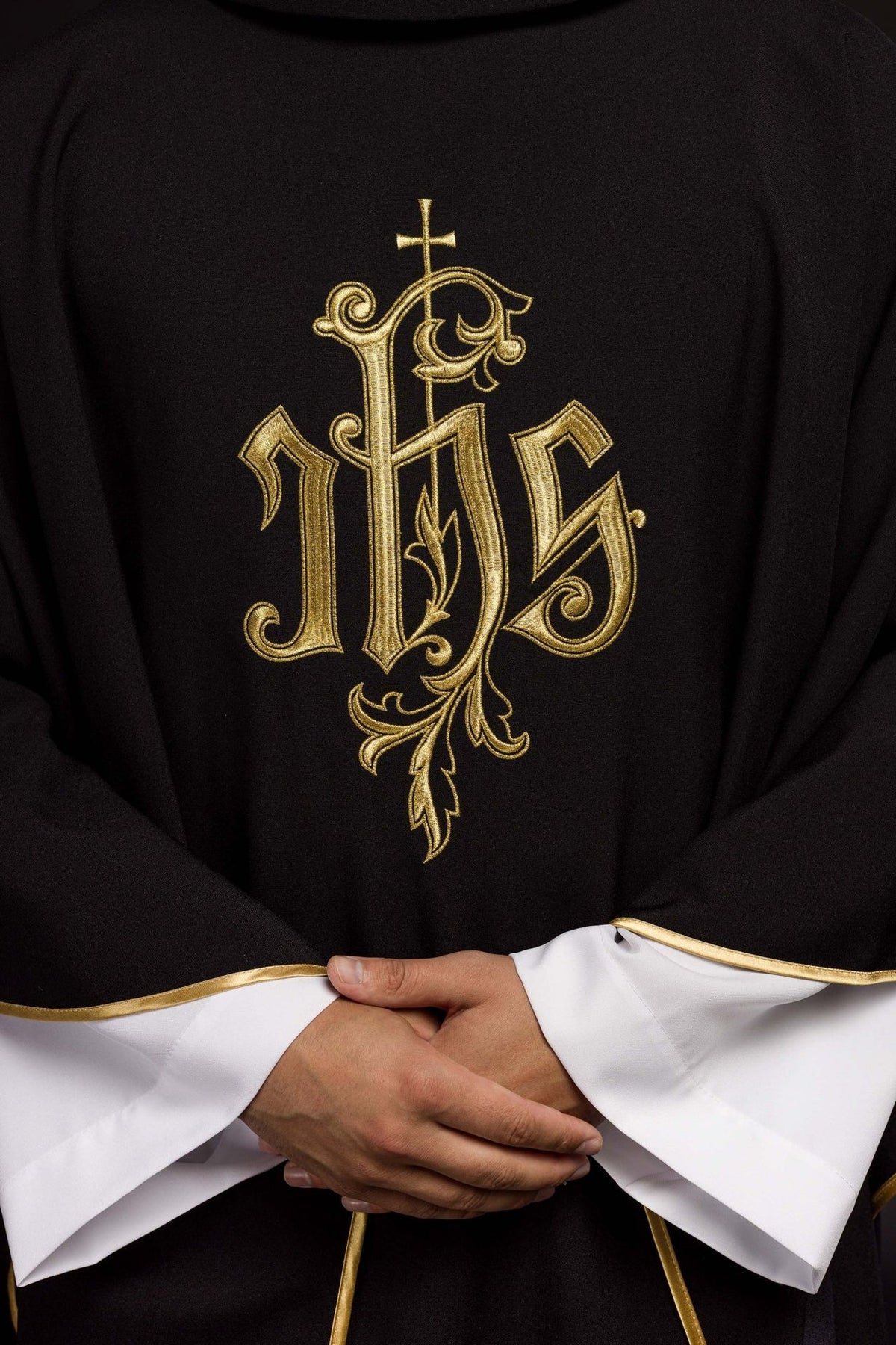 Black IHS chasuble close-up showing gold embroidery on the front