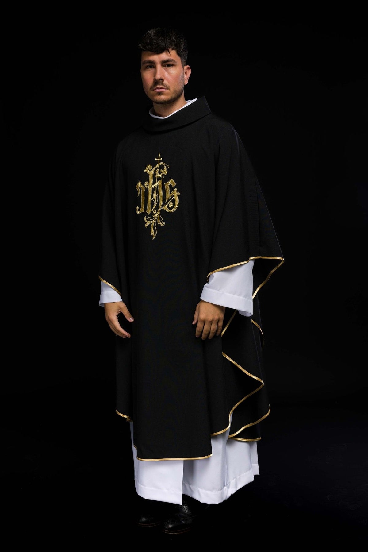 Black IHS chasuble worn three-quarter back view with gold trim