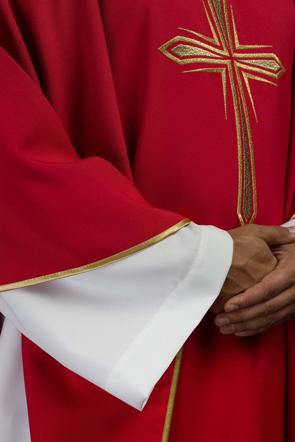 Red chasuble detail showing gold trim and embroidered cross