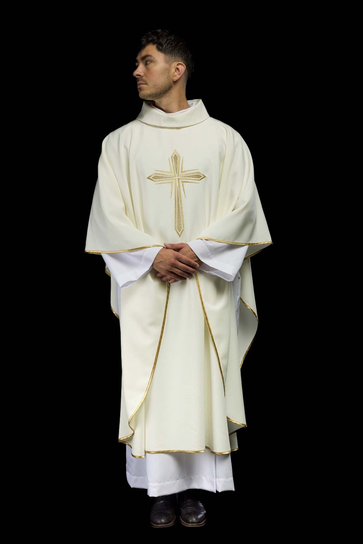 Ivory chasuble worn full length, showing gold cross embroidery and trim