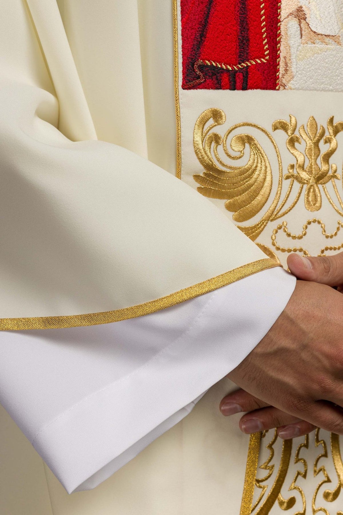White chasuble detail showing gold embroidered trim on the sleeve edge