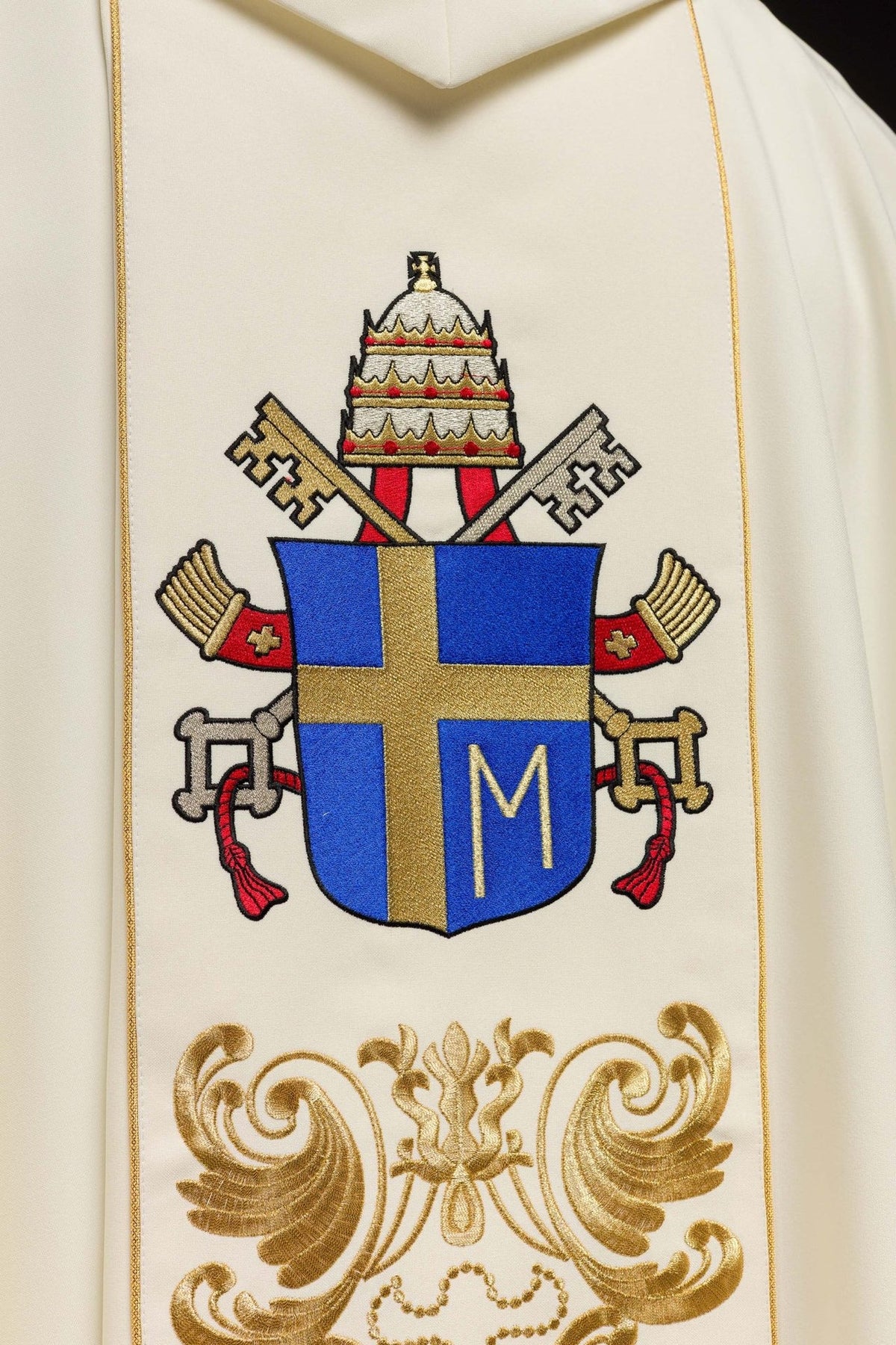 Chasuble back detail showing embroidered blue and gold papal coat of arms