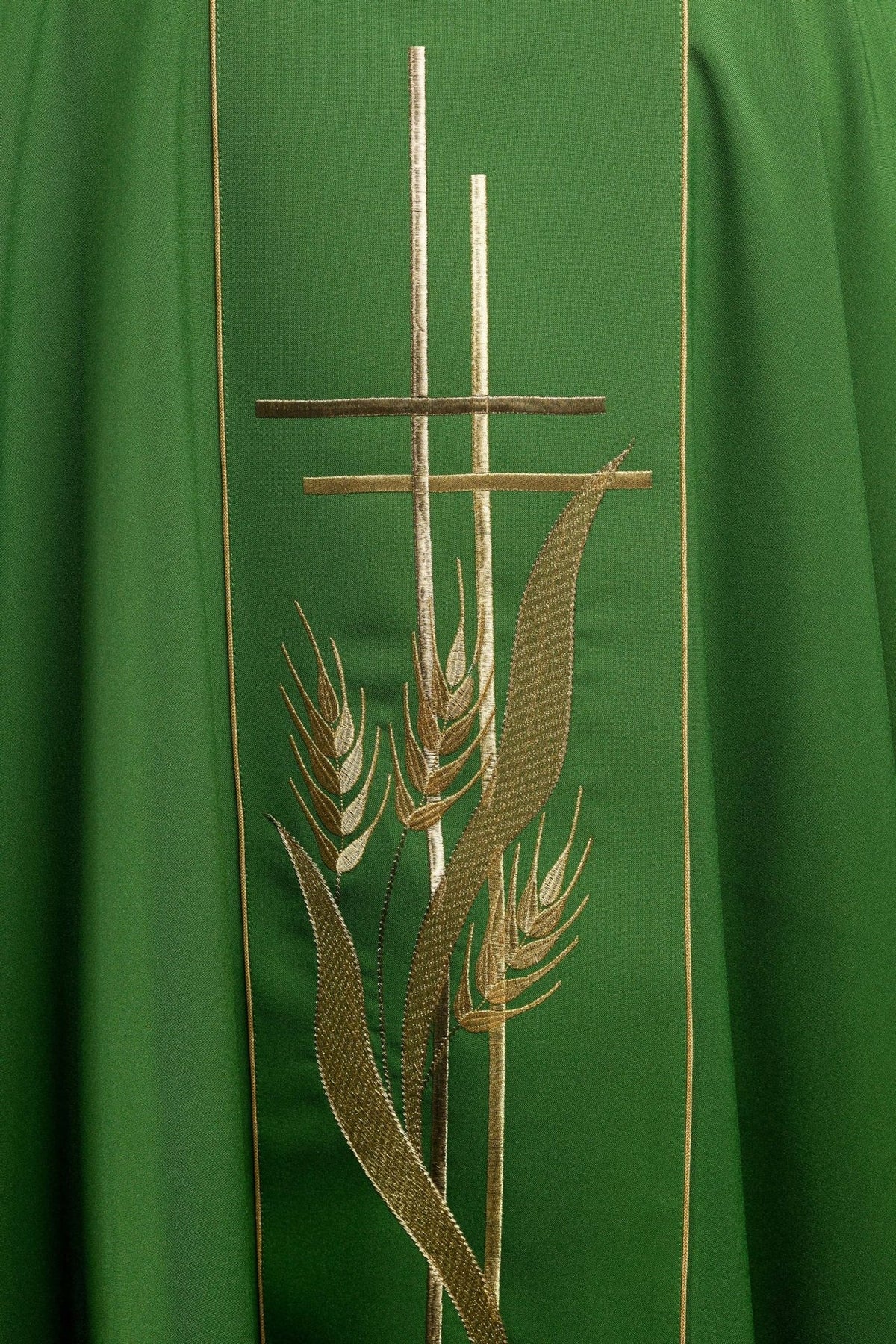 Green chasuble close-up showing gold cross and wheat embroidery