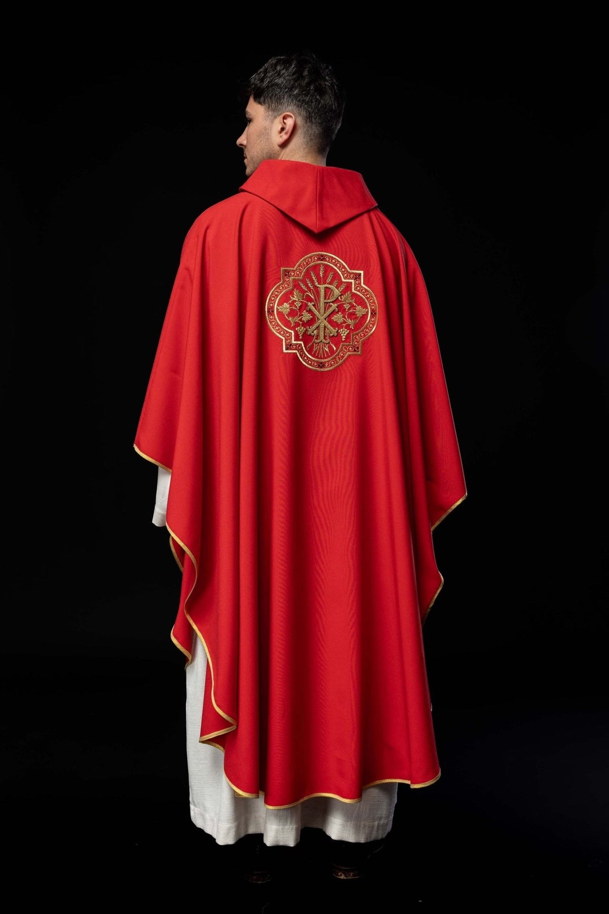 Red chasuble back view with gold PAX embroidery and trim