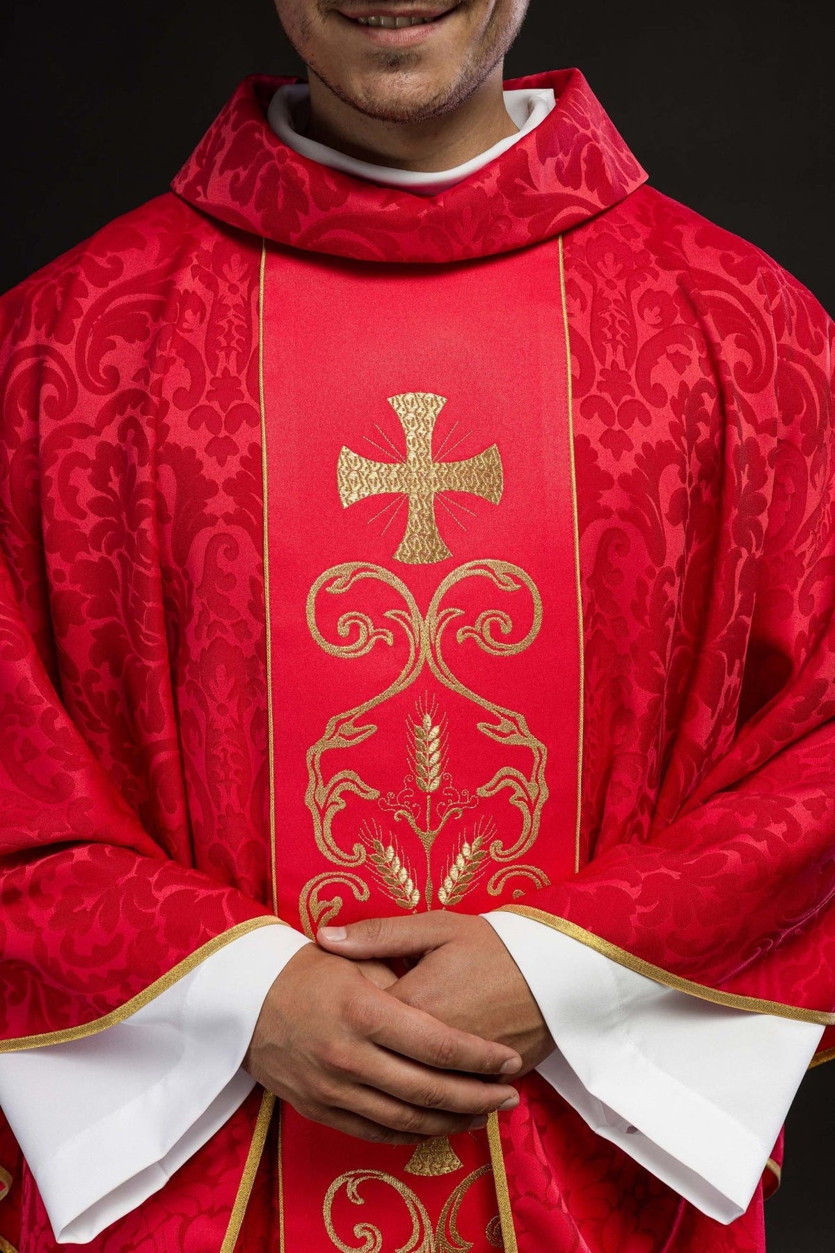 Red chasuble front close-up showing gold cross, orphrey embroidery and stand-up collar
