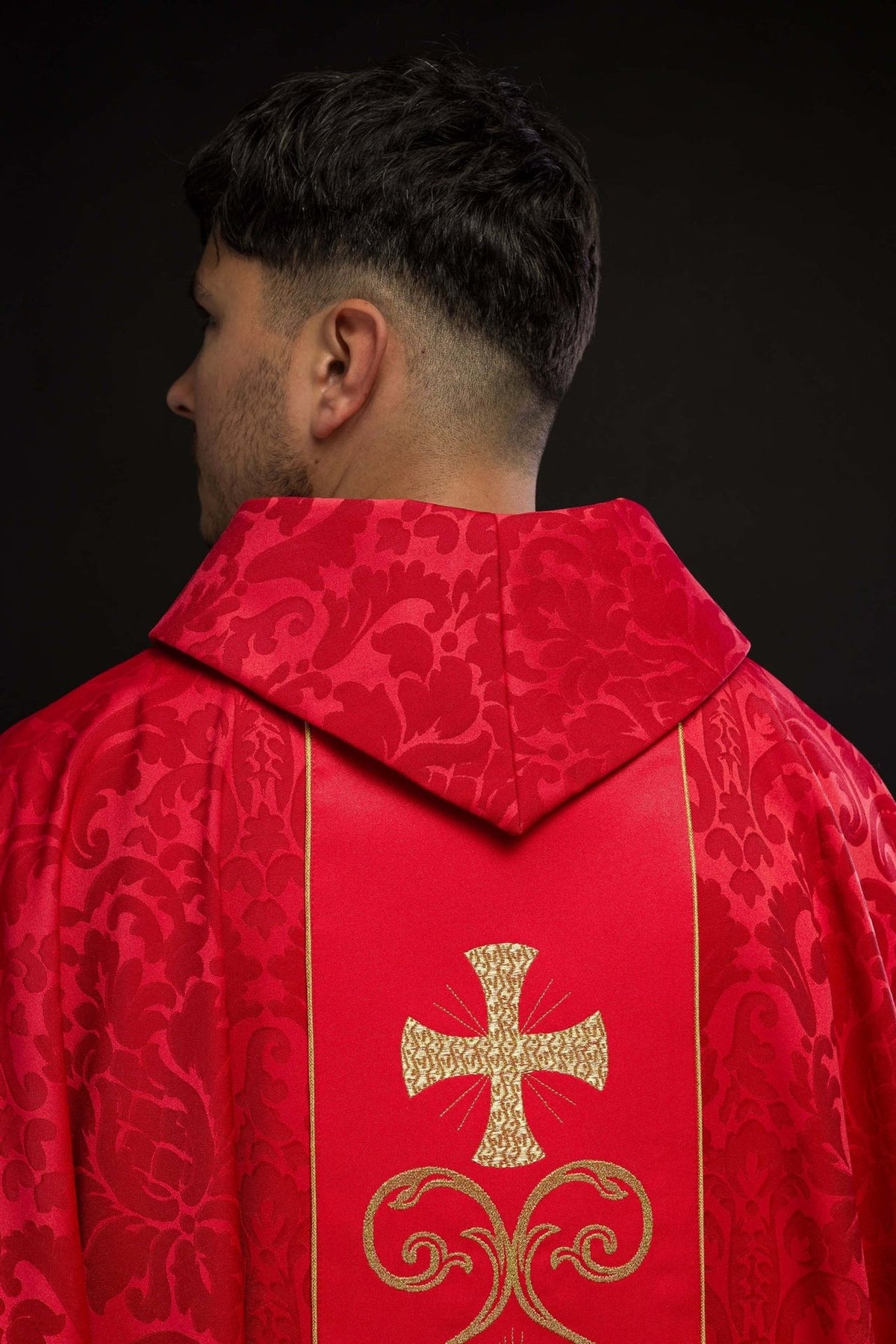 Red chasuble back close-up with gold embroidered cross and jacquard floral sleeves