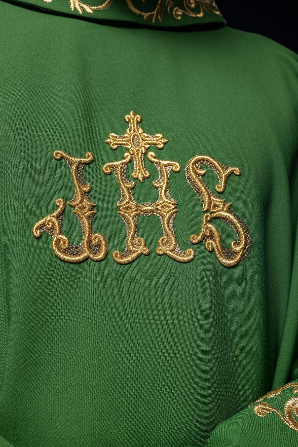 Green chasuble close-up showing gold IHS embroidery
