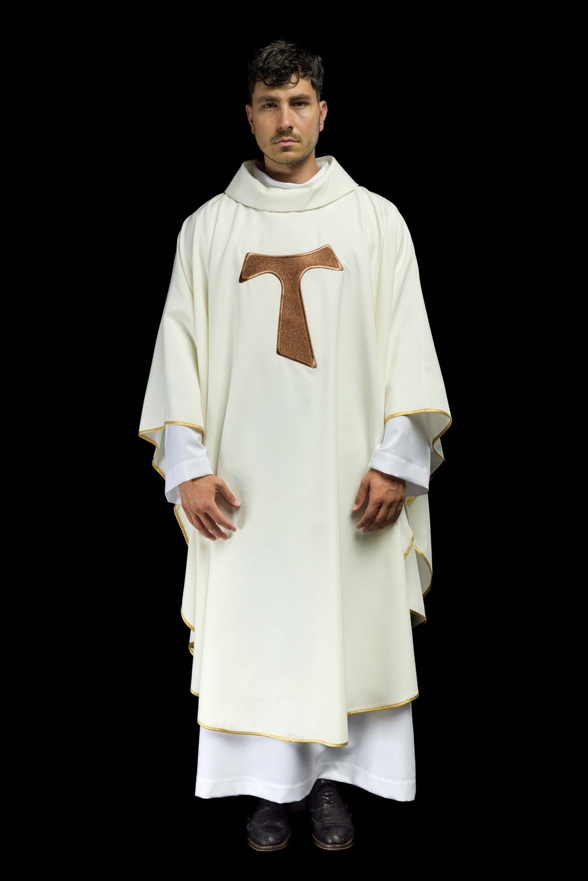 White liturgical chasuble worn front, showing the brown TAU cross and gold trim