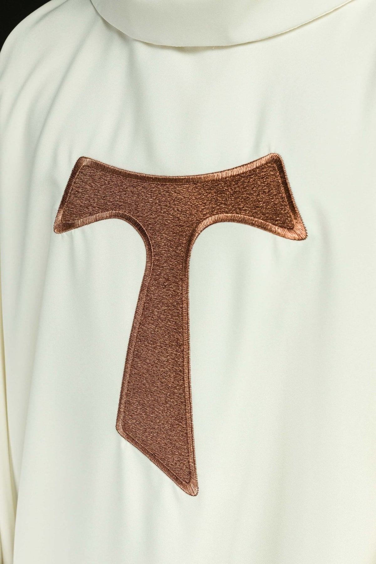 Chasuble front close-up with brown embroidered TAU cross on white fabric