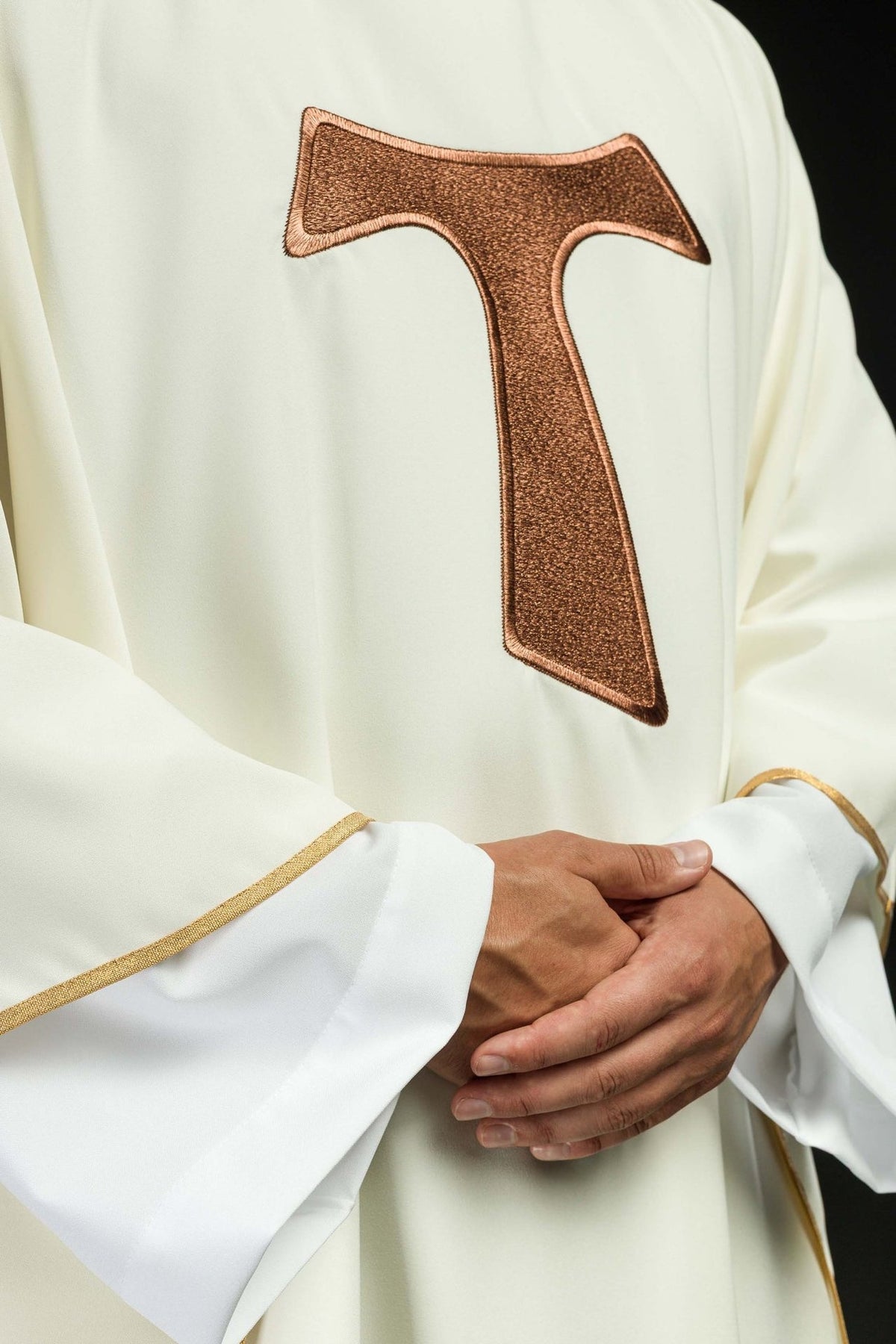 Brown embroidered TAU cross detail on the white chasuble front