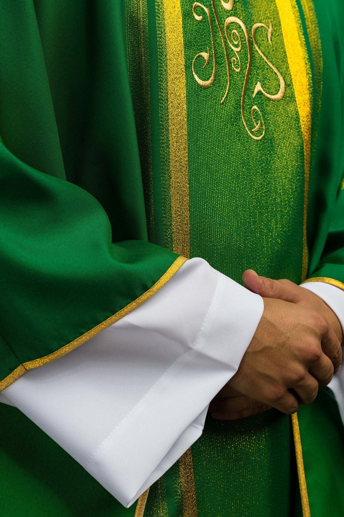 Green chasuble detail showing gold embroidery and satin fabric