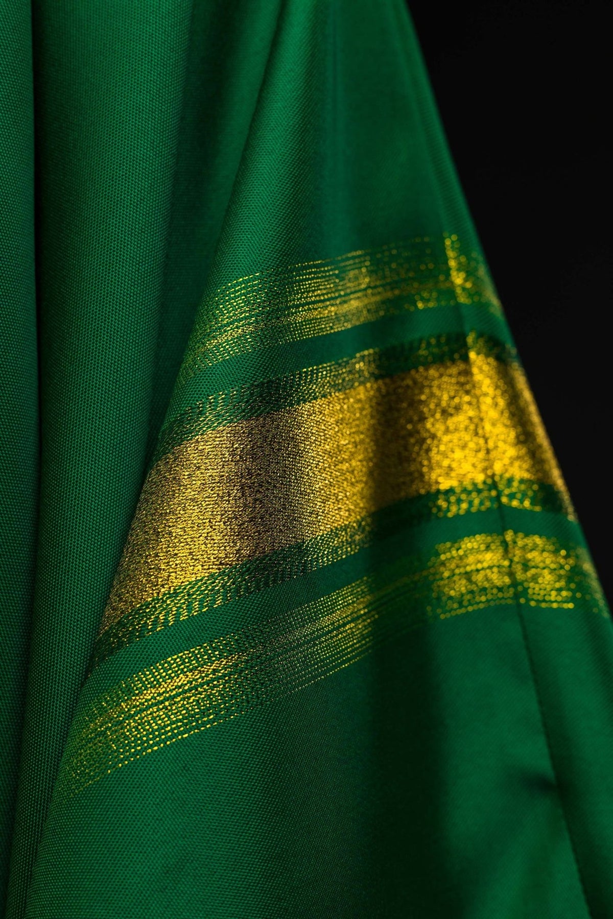 Green chasuble sleeve detail with gold trim and white cuff