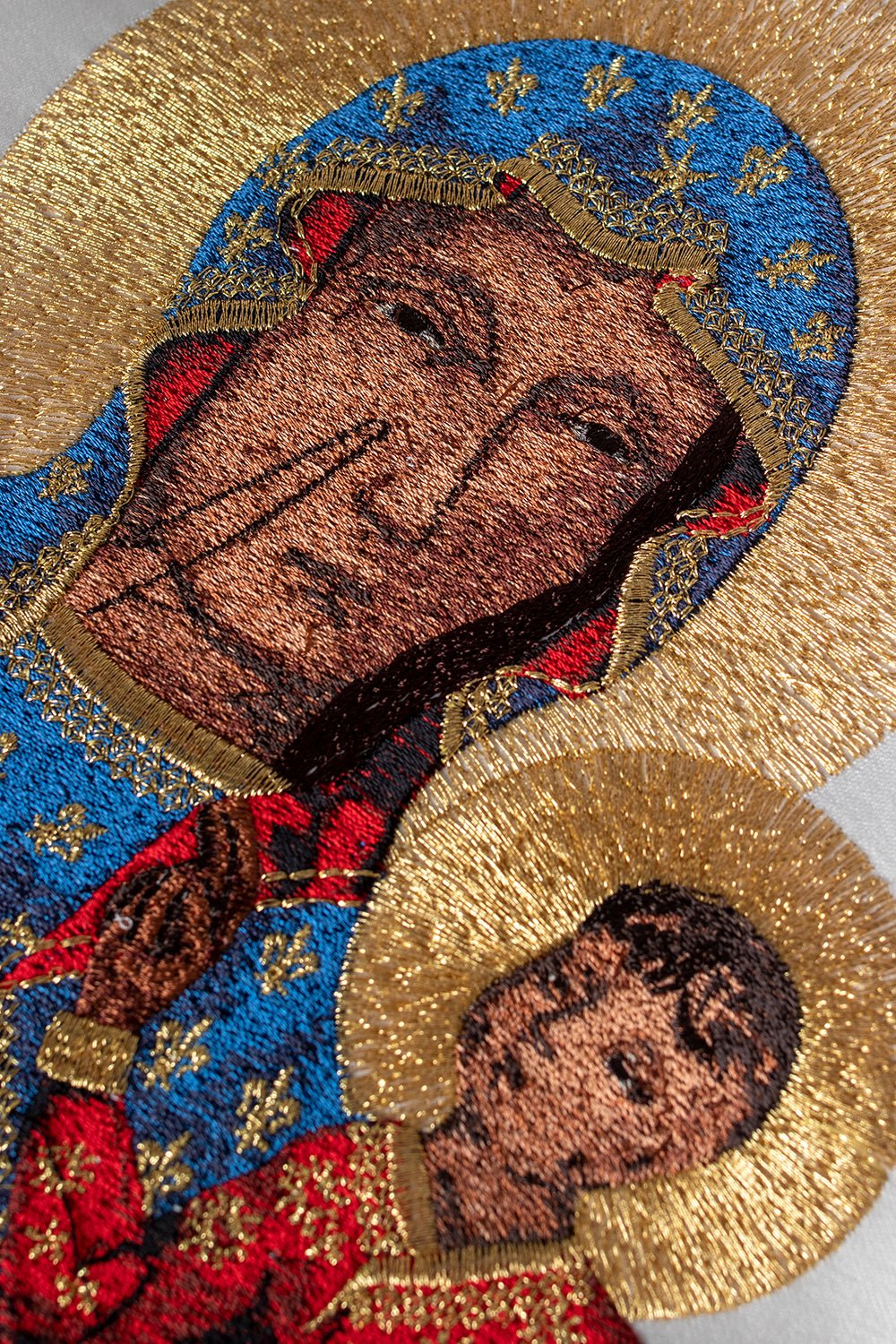 Ecru chasuble close-up showing detailed Our Lady embroidery and gold halos