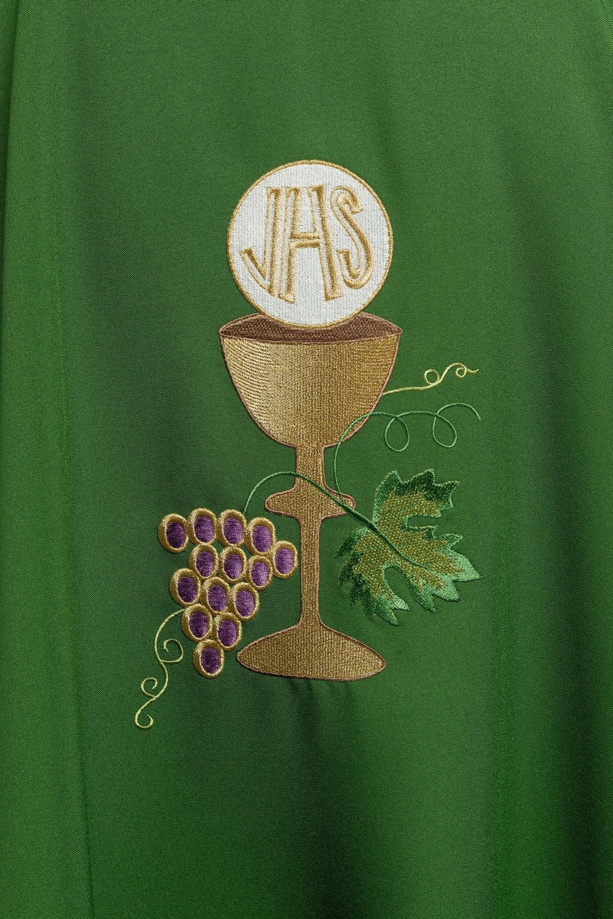 Green chasuble close-up with embroidered gold chalice and purple grapes