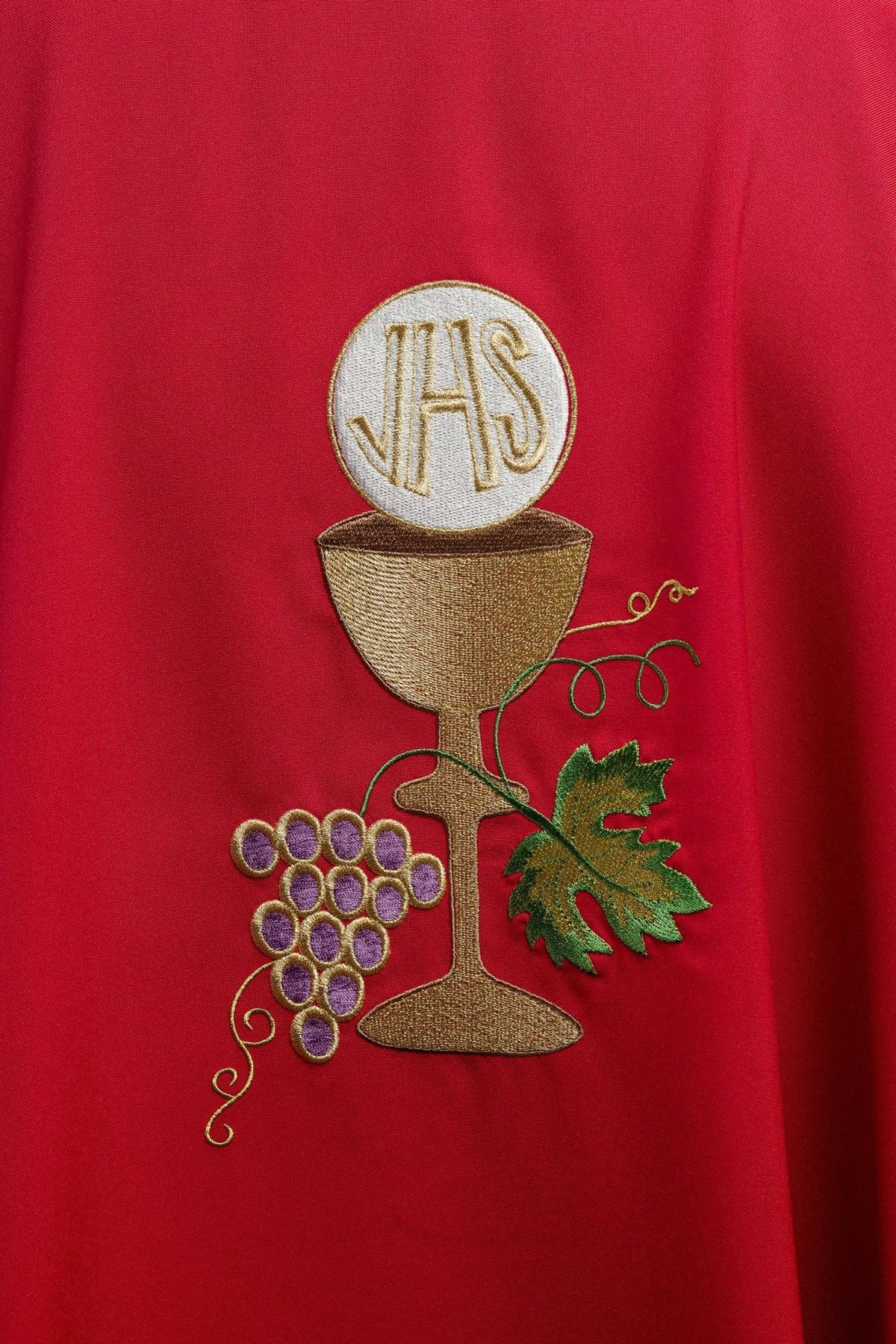 Red chasuble, close-up of gold chalice, cross and grapes embroidery