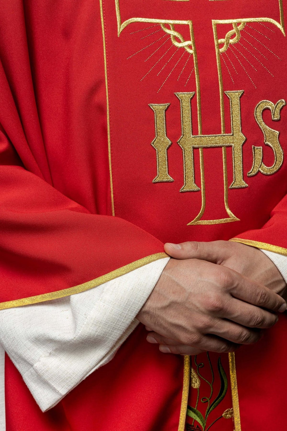 Red chasuble detail showing gold IHS embroidery and trim
