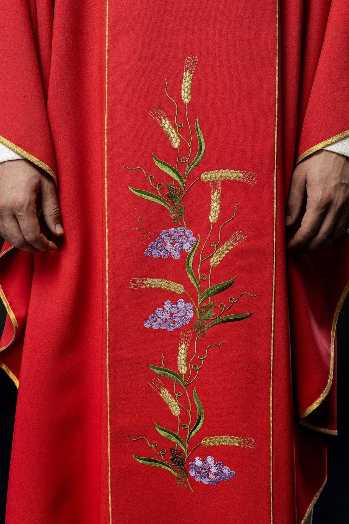 Red chasuble close-up of satin sleeve with gold trim