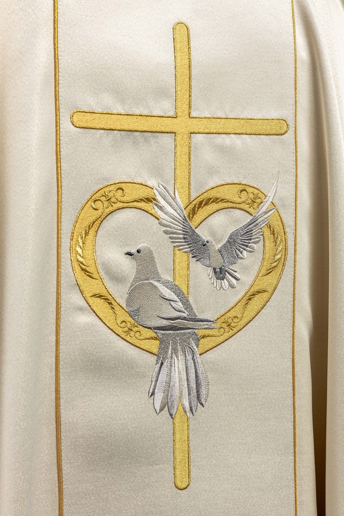 Wedding chasuble close-up of gold cross, heart and dove embroidery