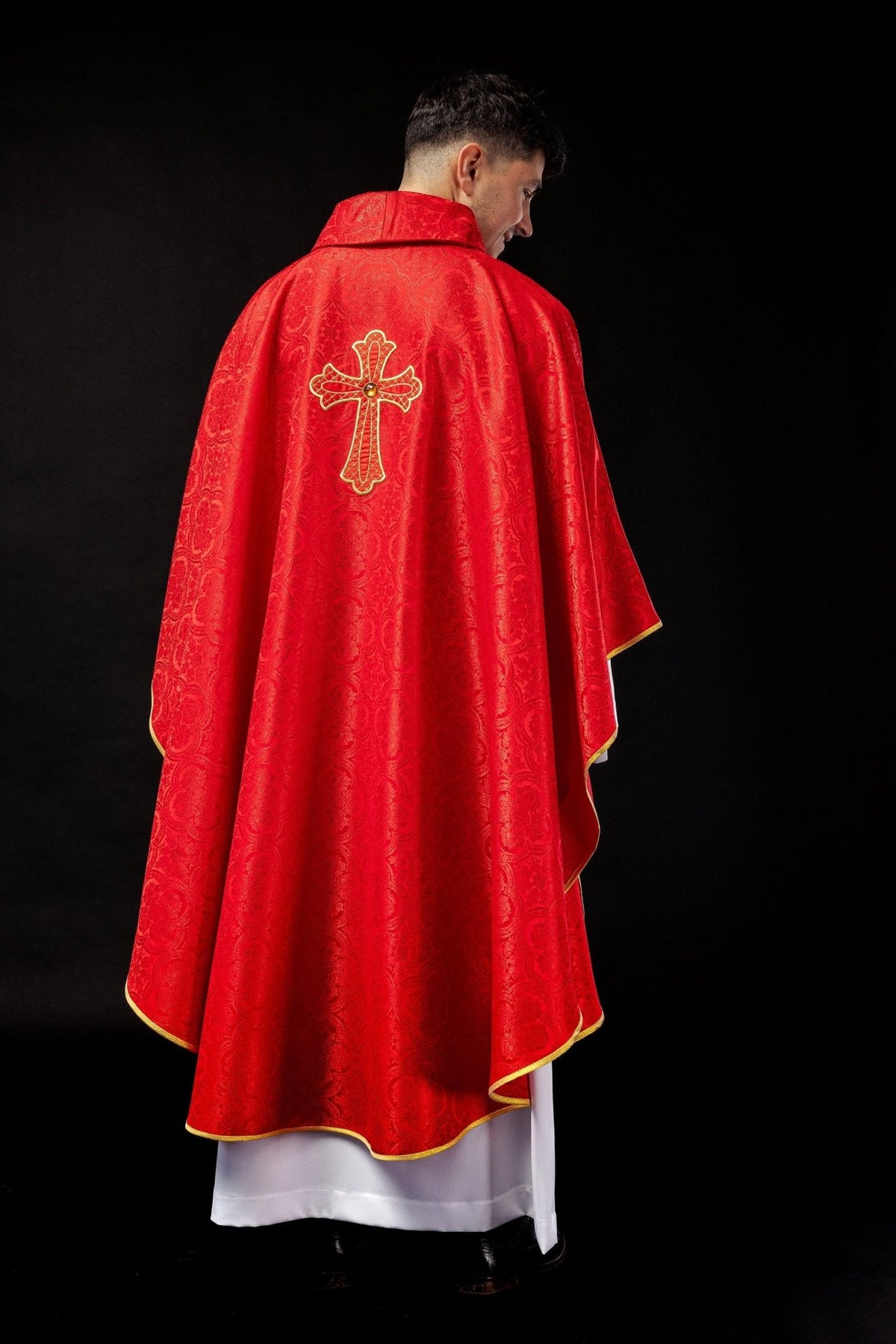Red chasuble back worn, showing gold trim and embroidered cross
