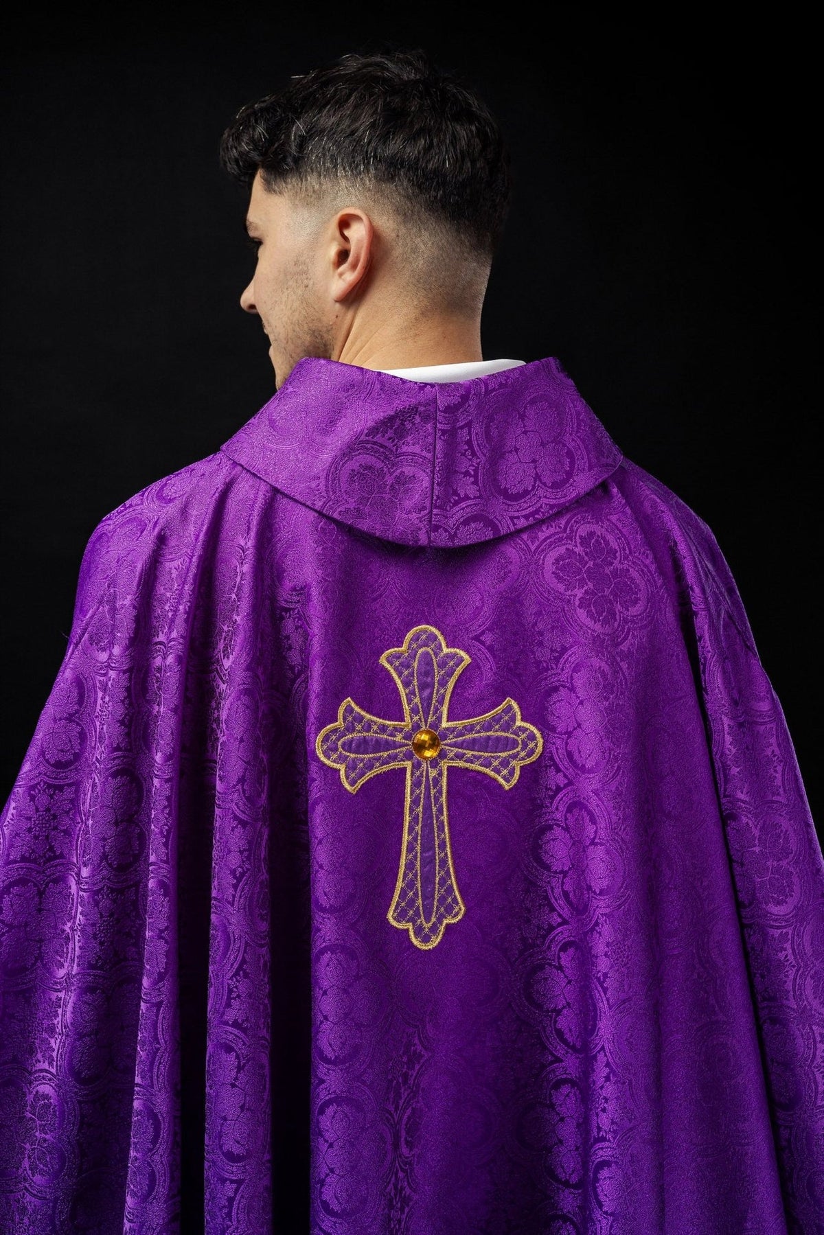 Purple chasuble back view with gold cross embroidery and patterned fabric