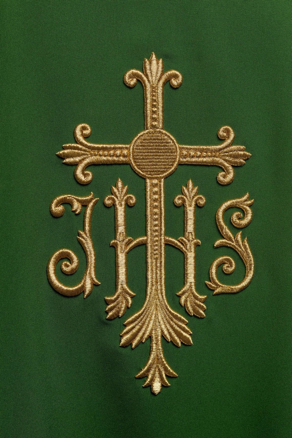 Green chasuble close-up showing raised gold JHS embroidery
