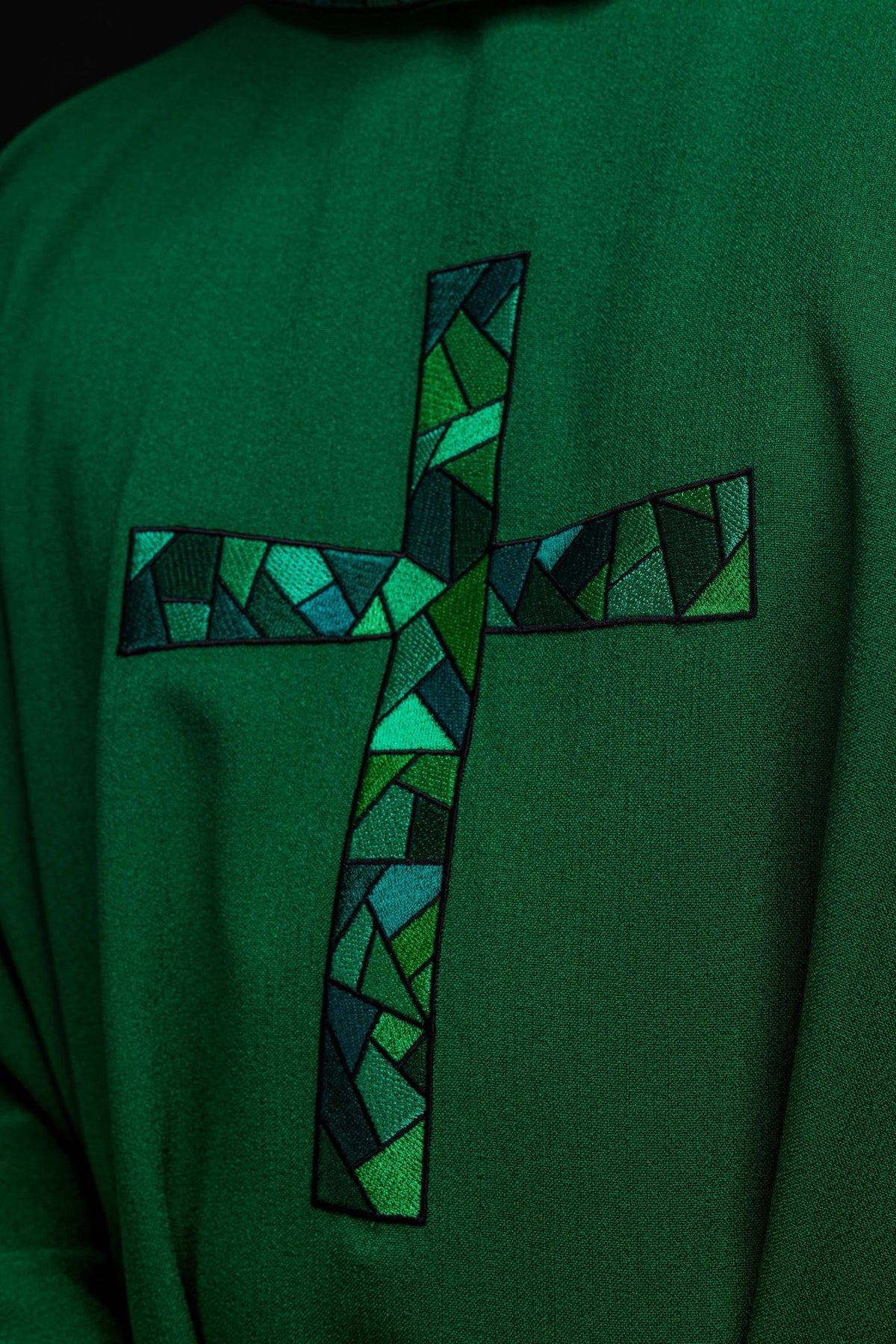 Green chasuble close-up showing mosaic cross embroidery