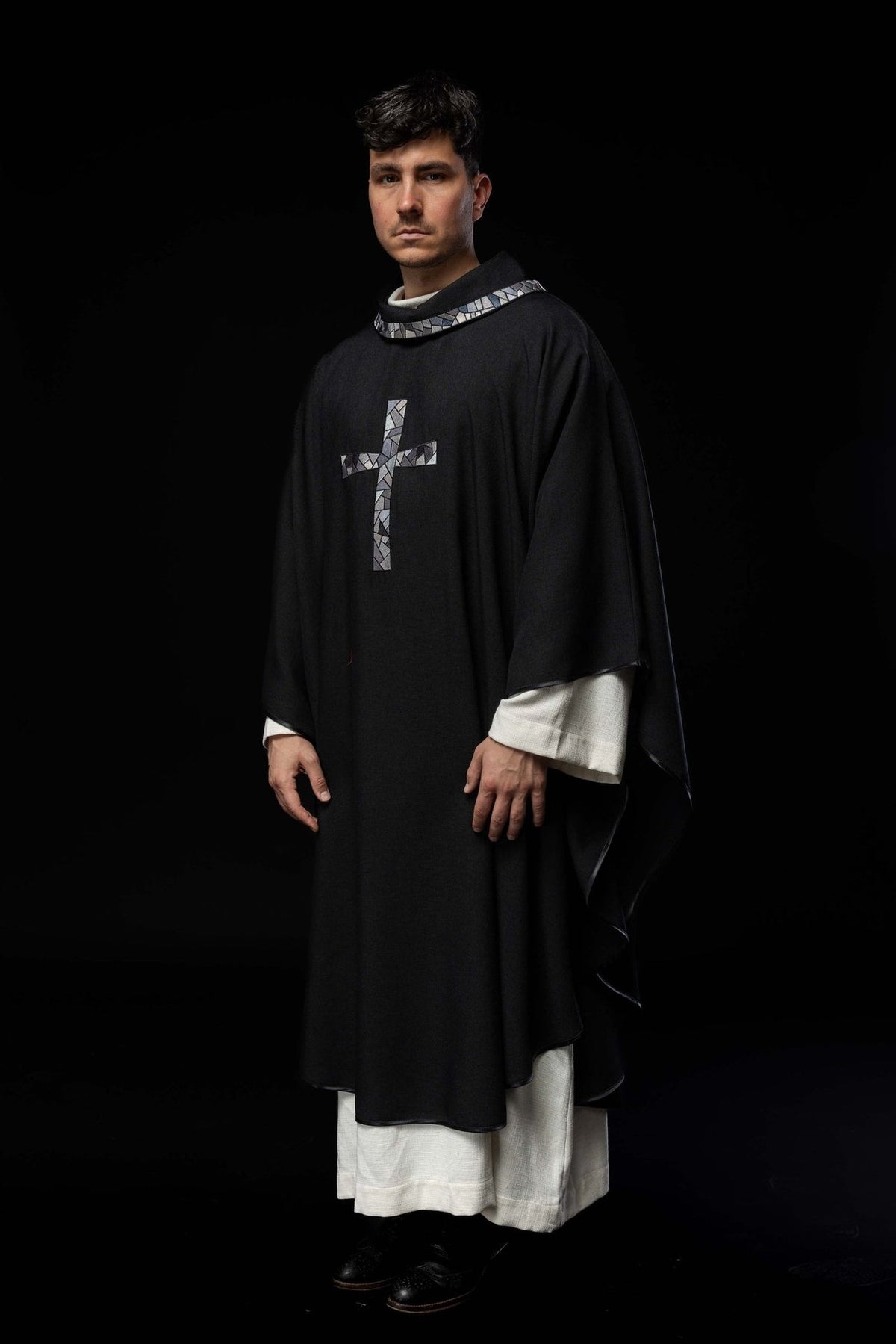 Black chasuble worn in a three-quarter front view with mosaic cross