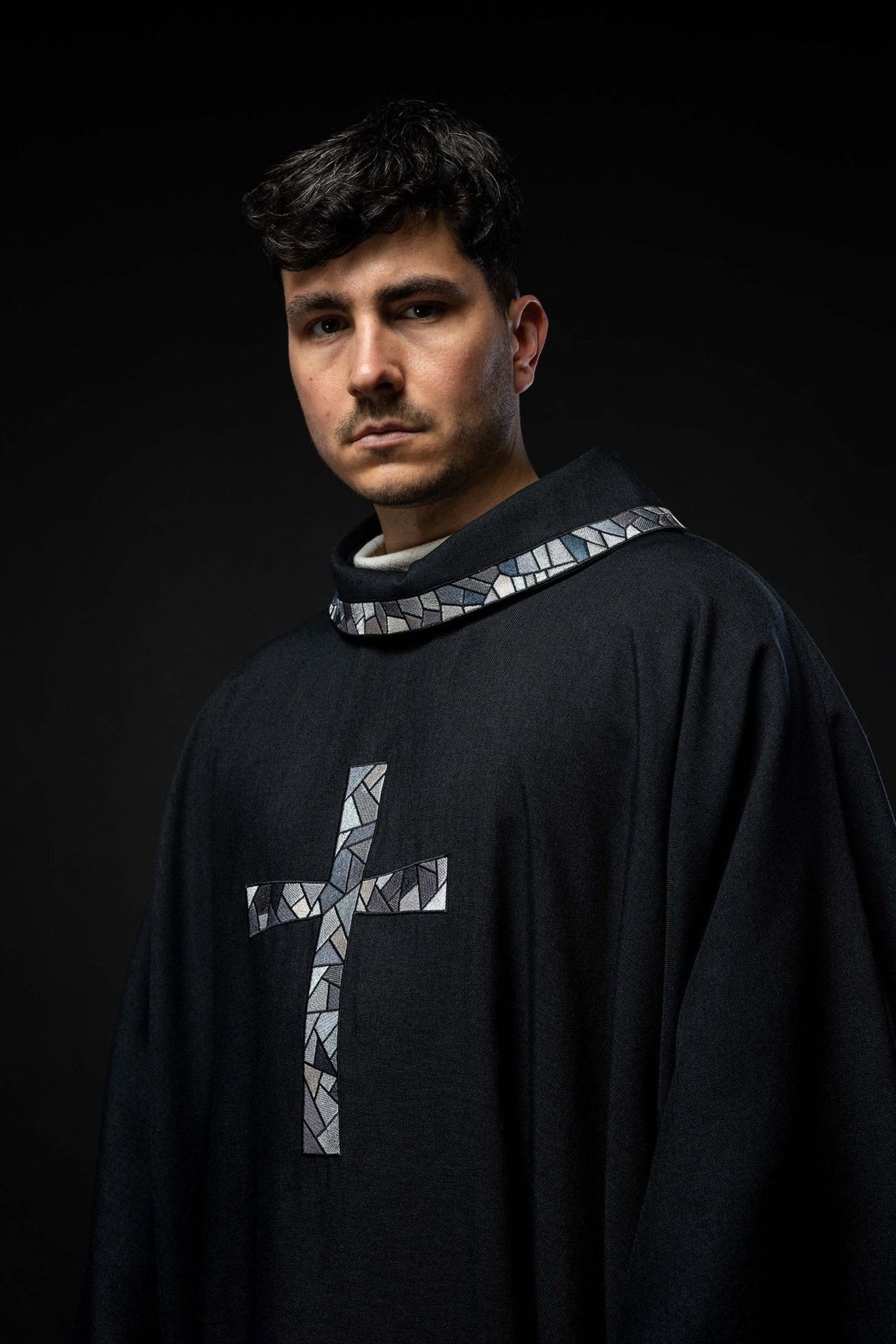 Black chasuble back view showing flowing shape and mosaic cross