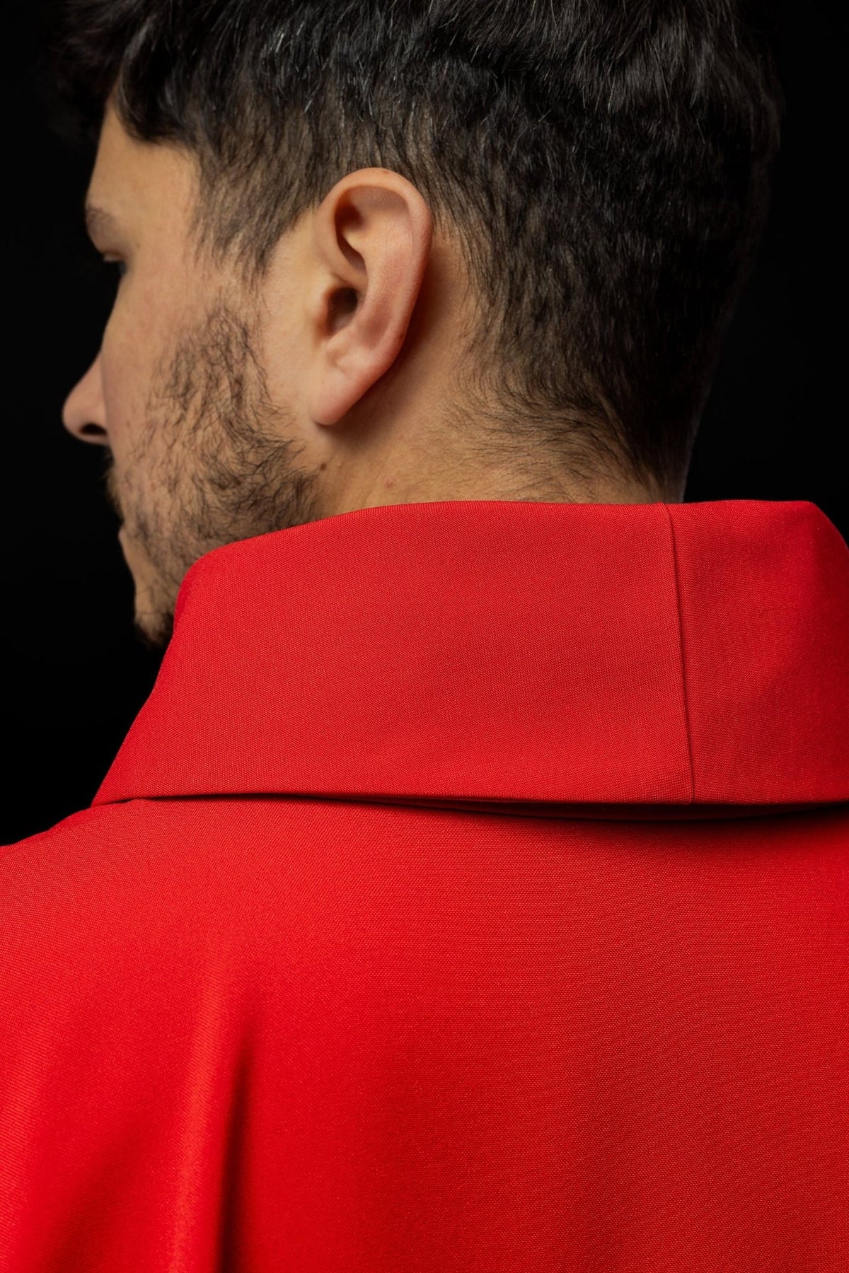 Red chasuble close-up showing white sleeves and gold trim