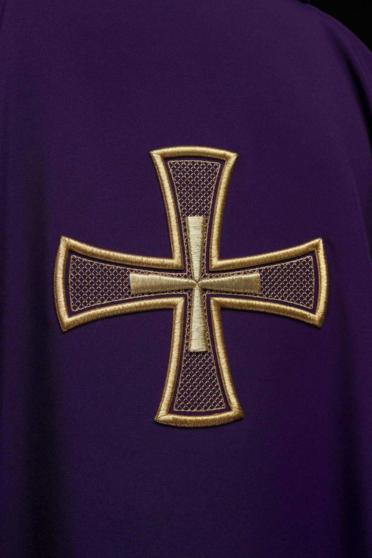 Purple chasuble close-up showing gold embroidered cross